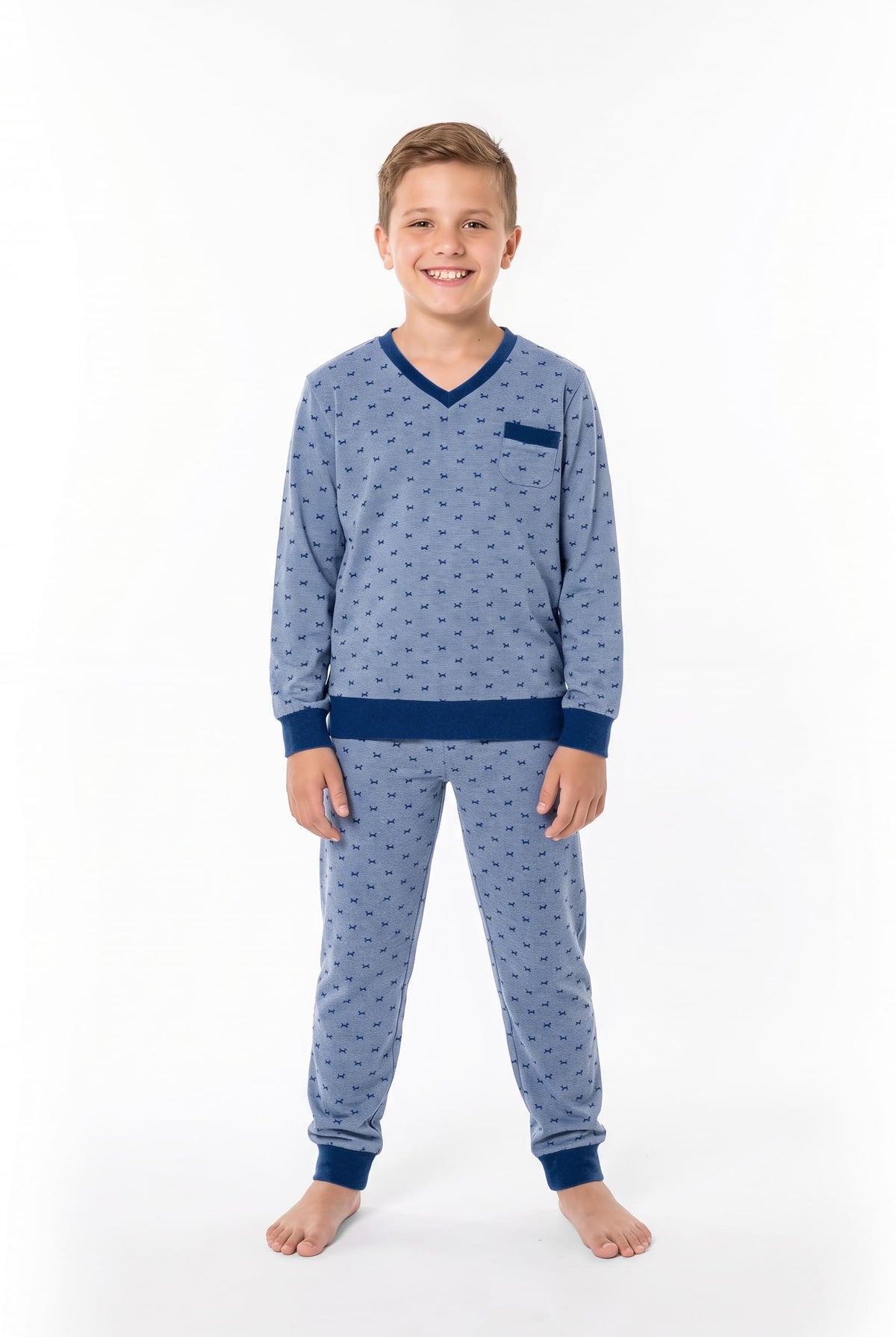 Un niño posa luciendo un pijama de invierno decorado con divertidos perritos.