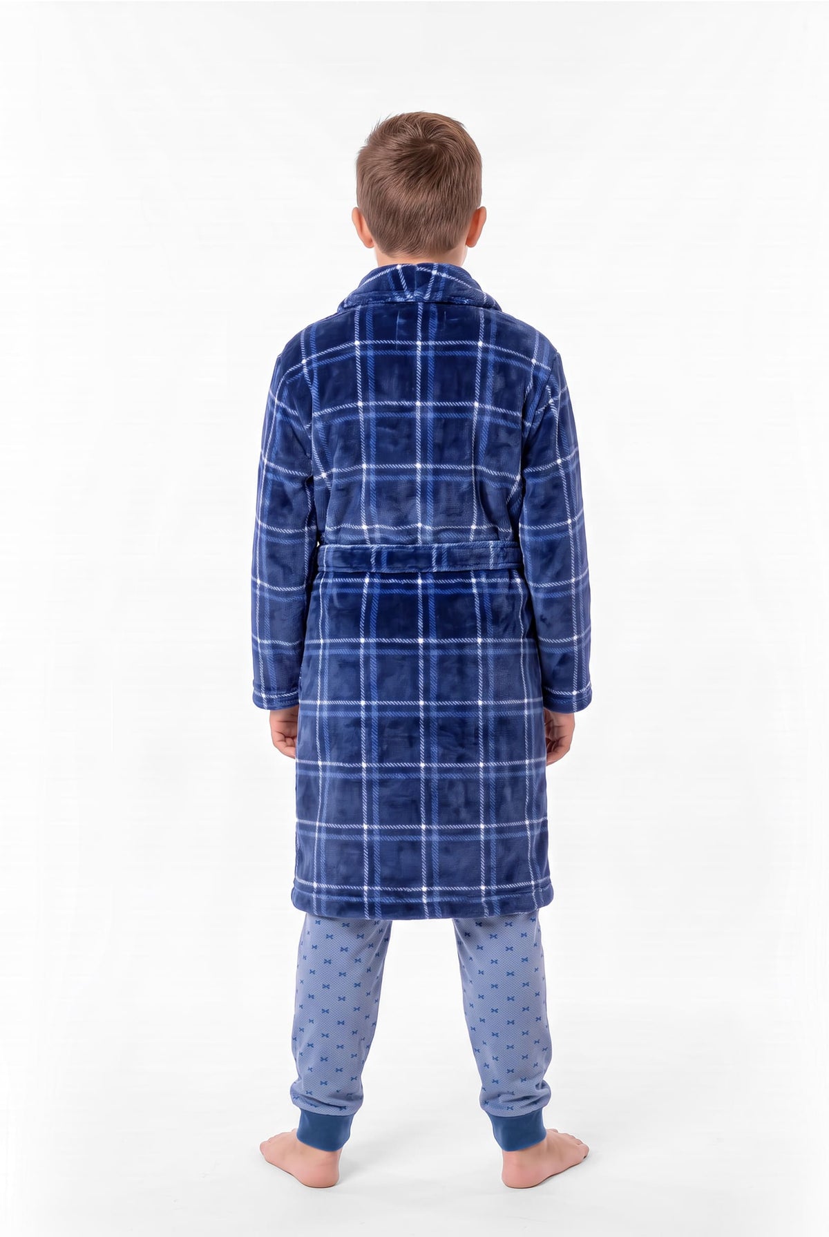 Niño de espaldas con bata de invierno de cuadros azules con cinturón sobre un pijama azul claro