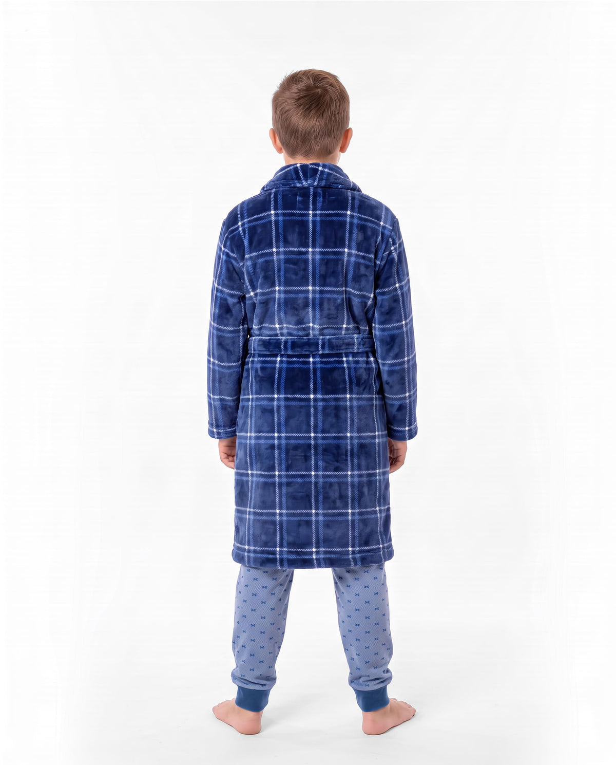 Niño de espaldas con bata de invierno de cuadros azules con cinturón sobre un pijama azul claro