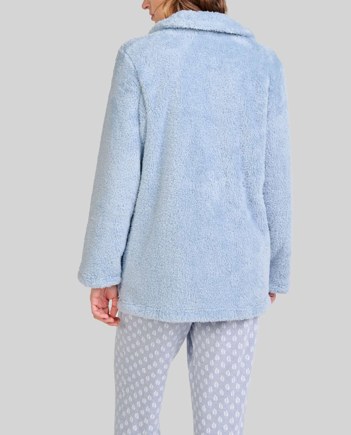 Mujer de espaldas con bata cálida de rizo azul claro ideal para invierno
