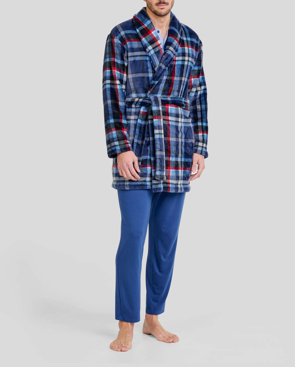 Hombre con bata corta de cuadros azul, rojo y blanco con cinturón y pijama azul