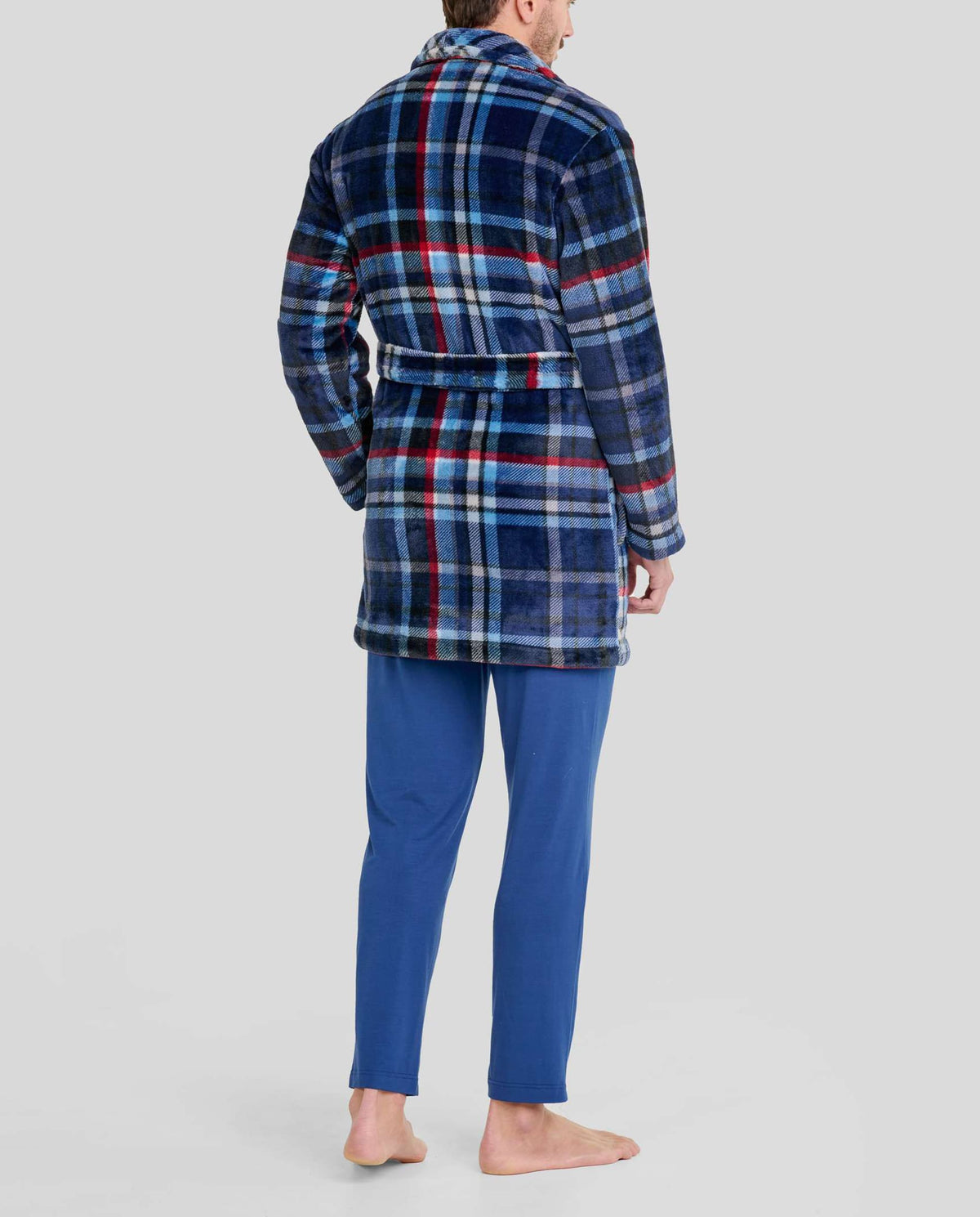 Hombre de espaldas con bata azul a cuadros y cinturón, y pantalón pijama azul