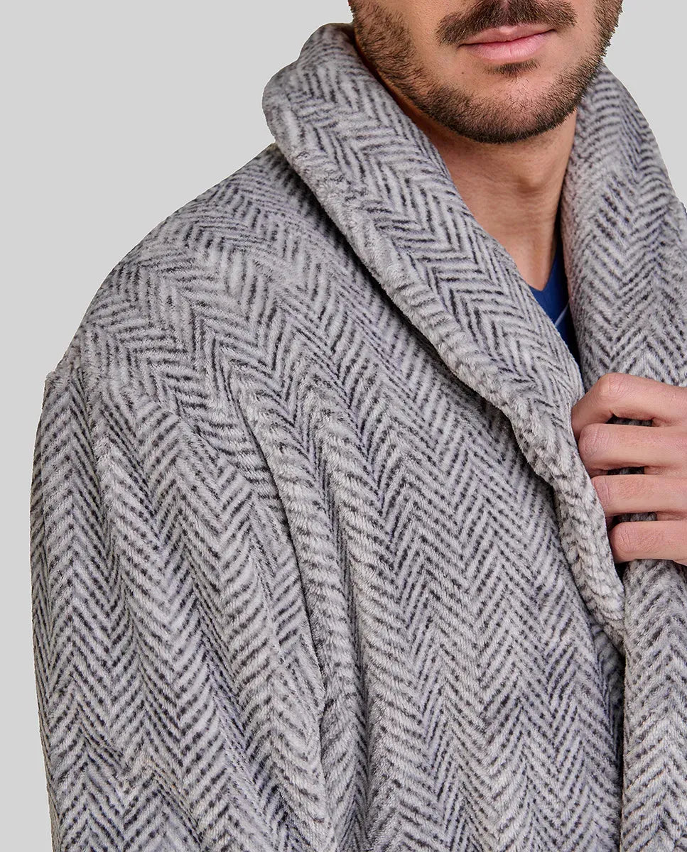 Elegante hombre sujetando el cuello smoking de su bata gris de diseño espiga