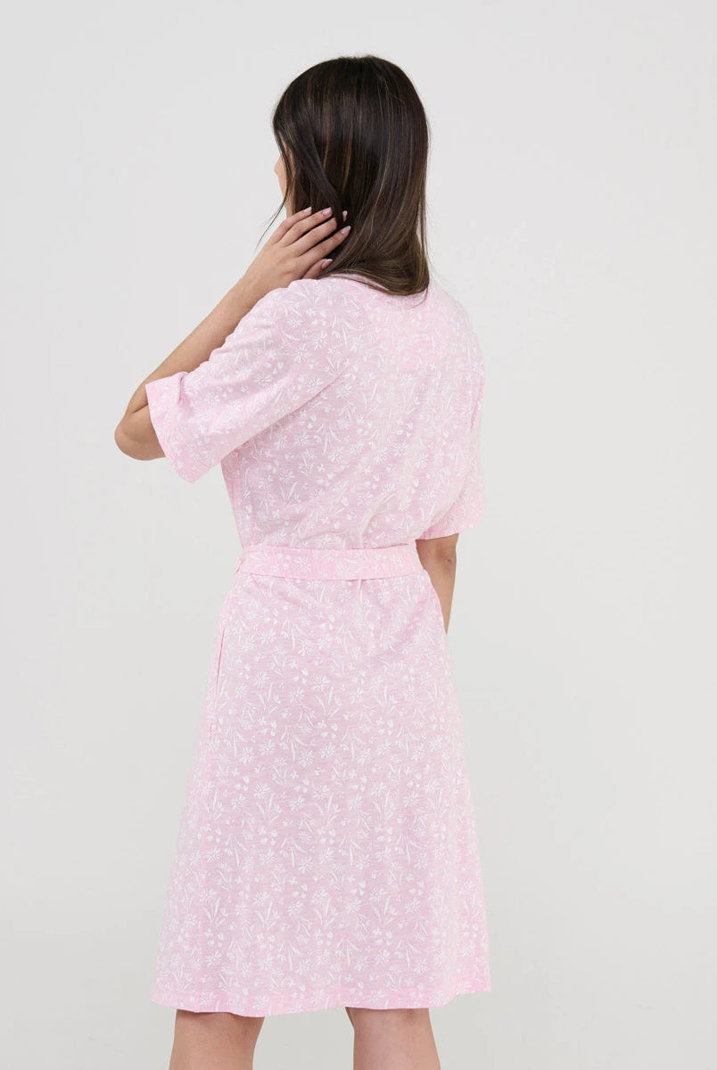 Vista trasera de mujer con bata rosa y estampado florecitas blancas