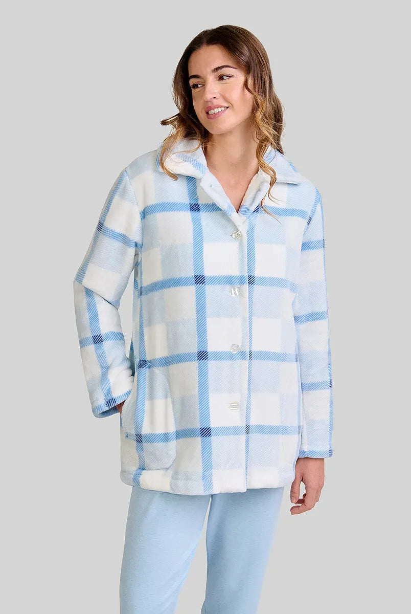 mujer luce bata corta de cuadros azul y blanco con botones y bolsillos laterales