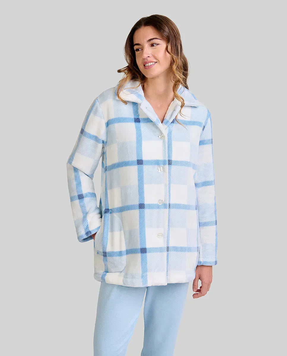 mujer luce bata corta de cuadros azul y blanco con botones y bolsillos laterales