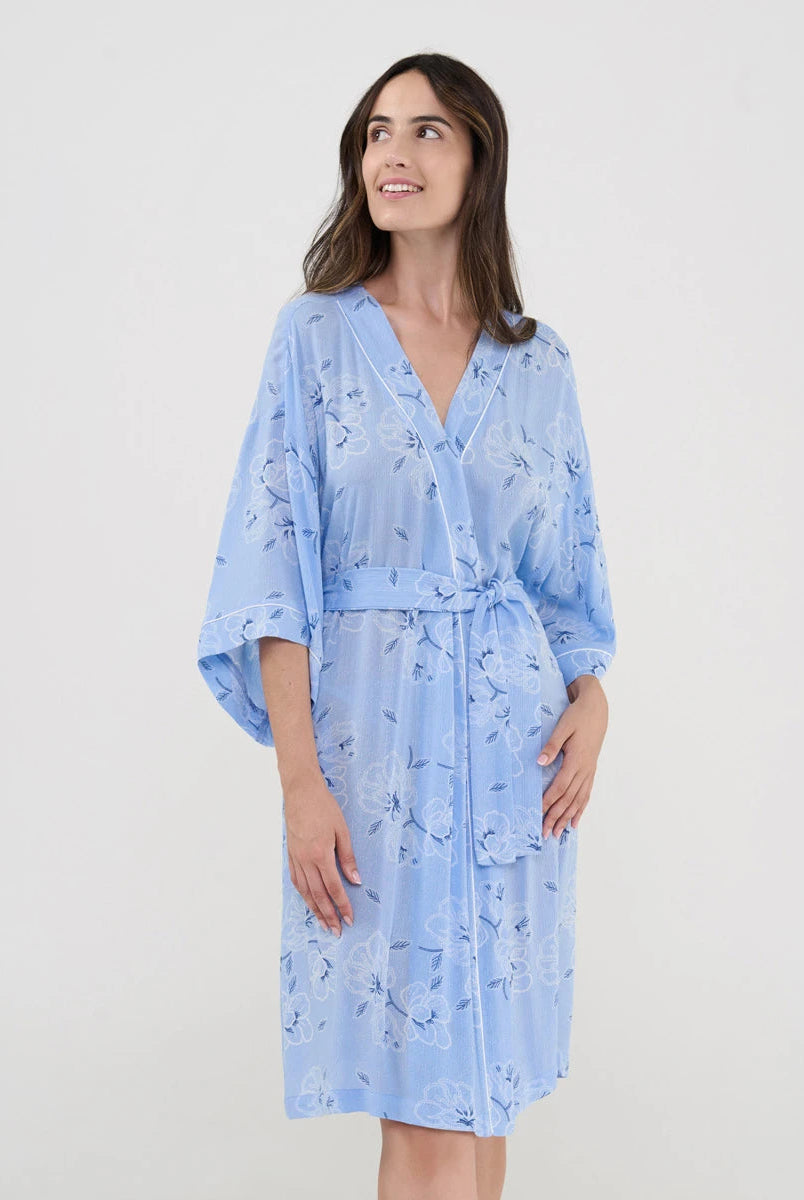 Mujer luce ligera y confortable bata corta de verano cruzada estampado celeste de flores