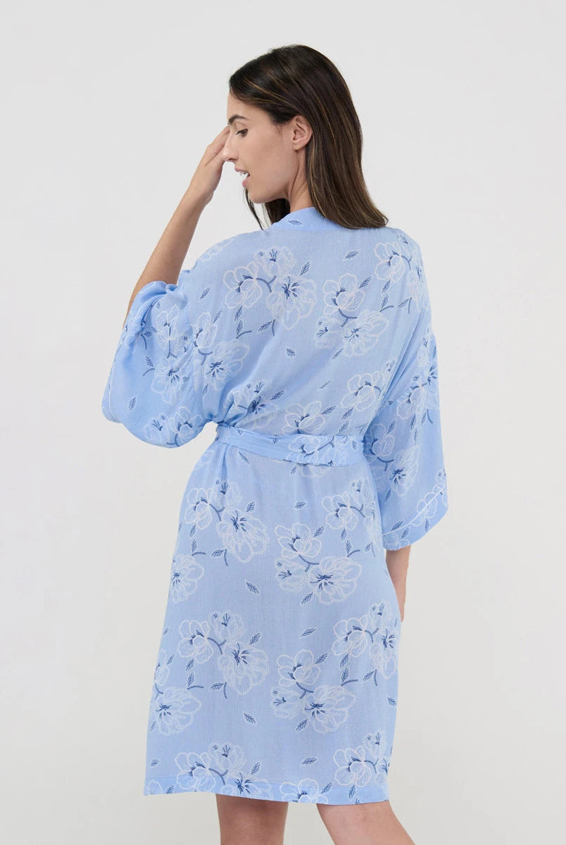 Vista de espaldas de mujer con bata cruzada celeste para verano