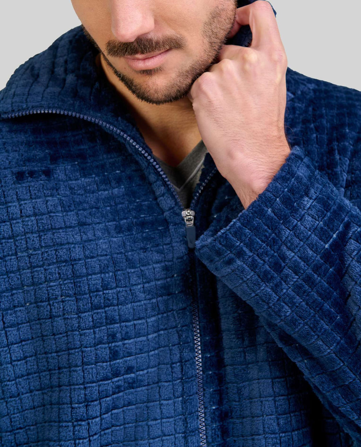 Hombre con una elegante bata azul marino con cremallera y tejido jacquard de cuadros