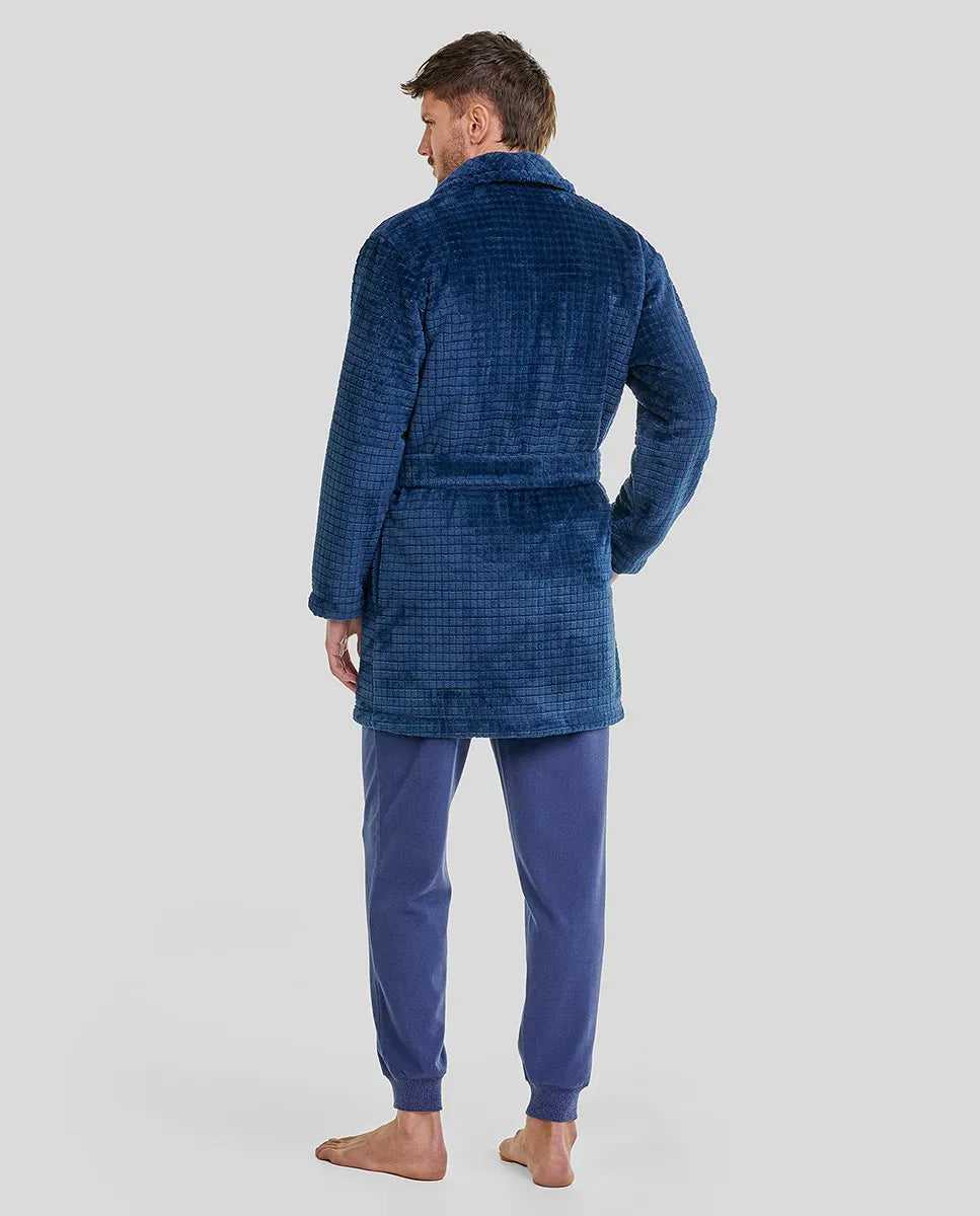 Hombre de espaldas con bata corta azul marino de bolsillos y pijama azul