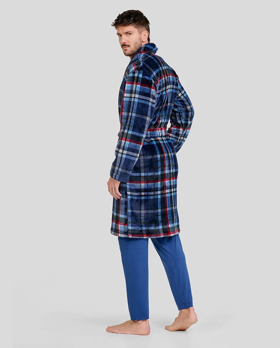 Hombre posando de perfil con bata smoking azul de cuadros y pantalones azules