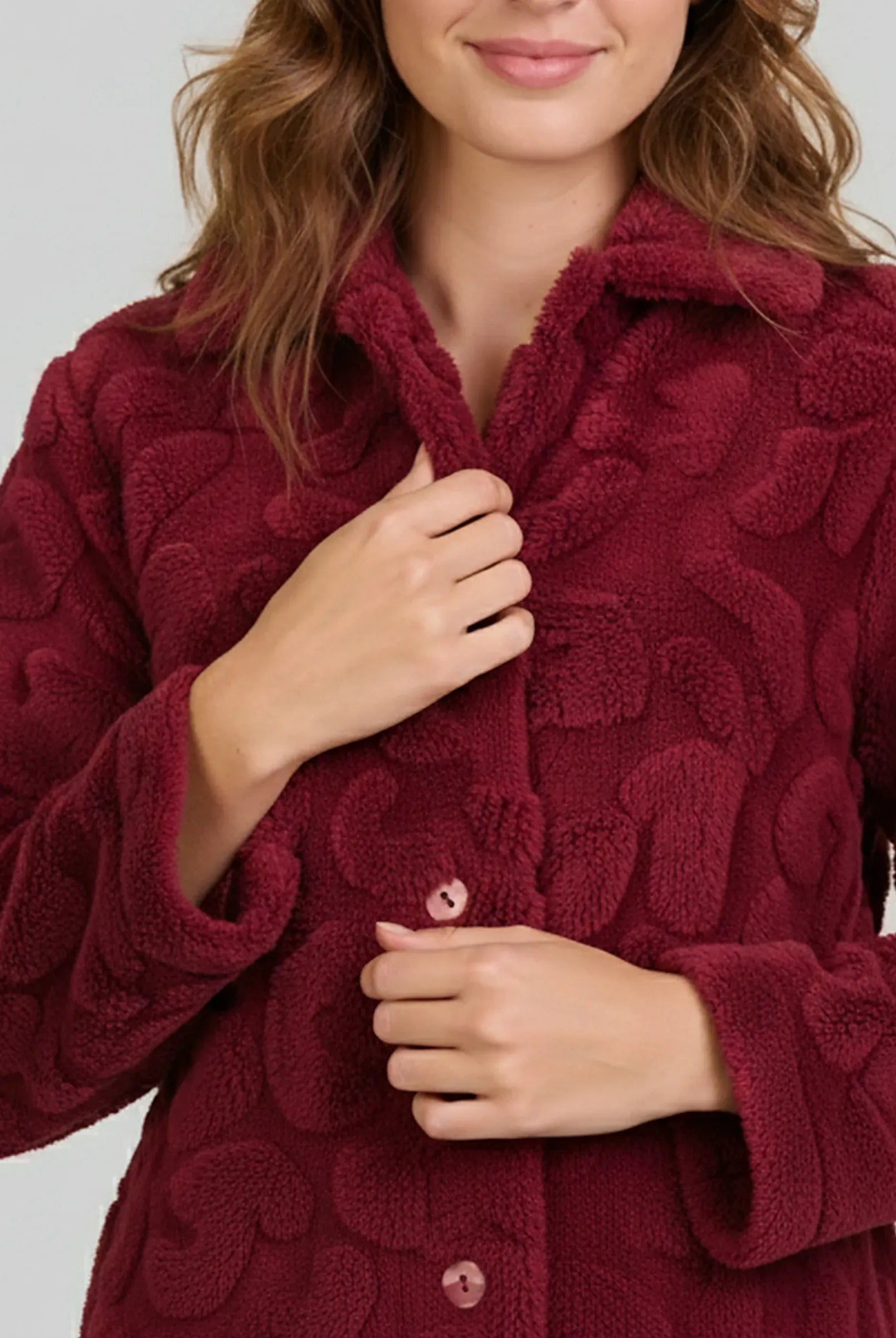 Detalle de bata de invierno para mujer abotonada en elegante jacquard granate