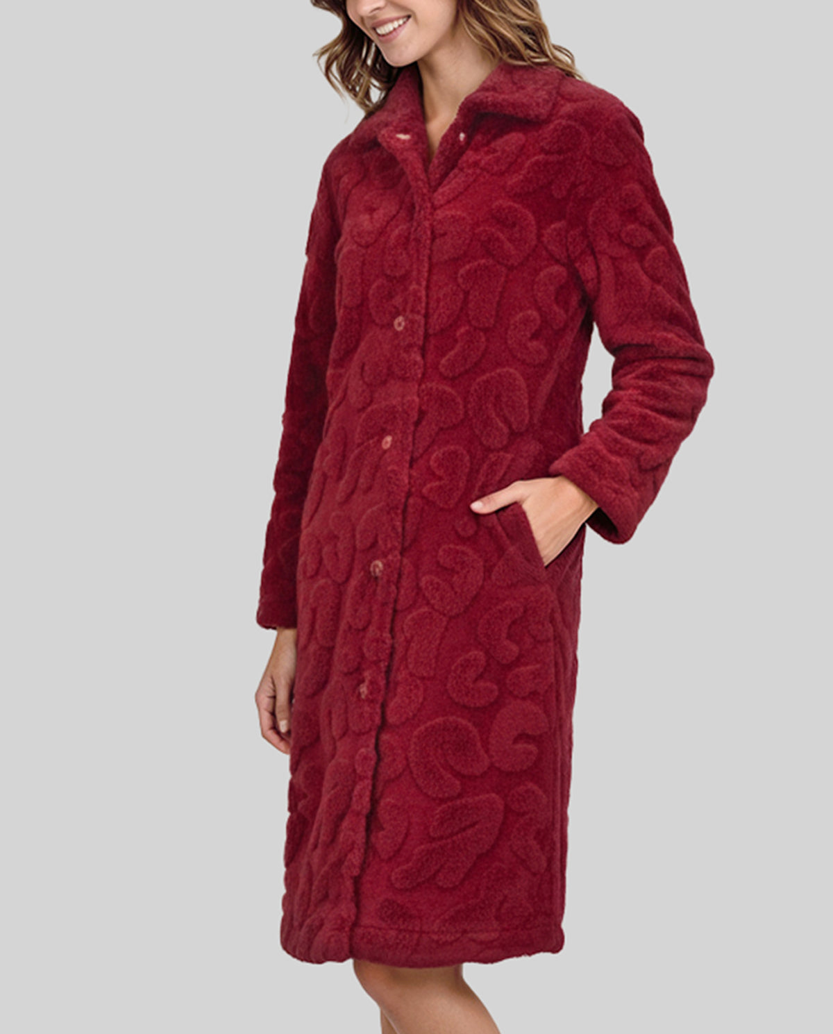 Mujer con bata larga de invierno abotonada y con bolsillos en amoroso tejido jacquard granate