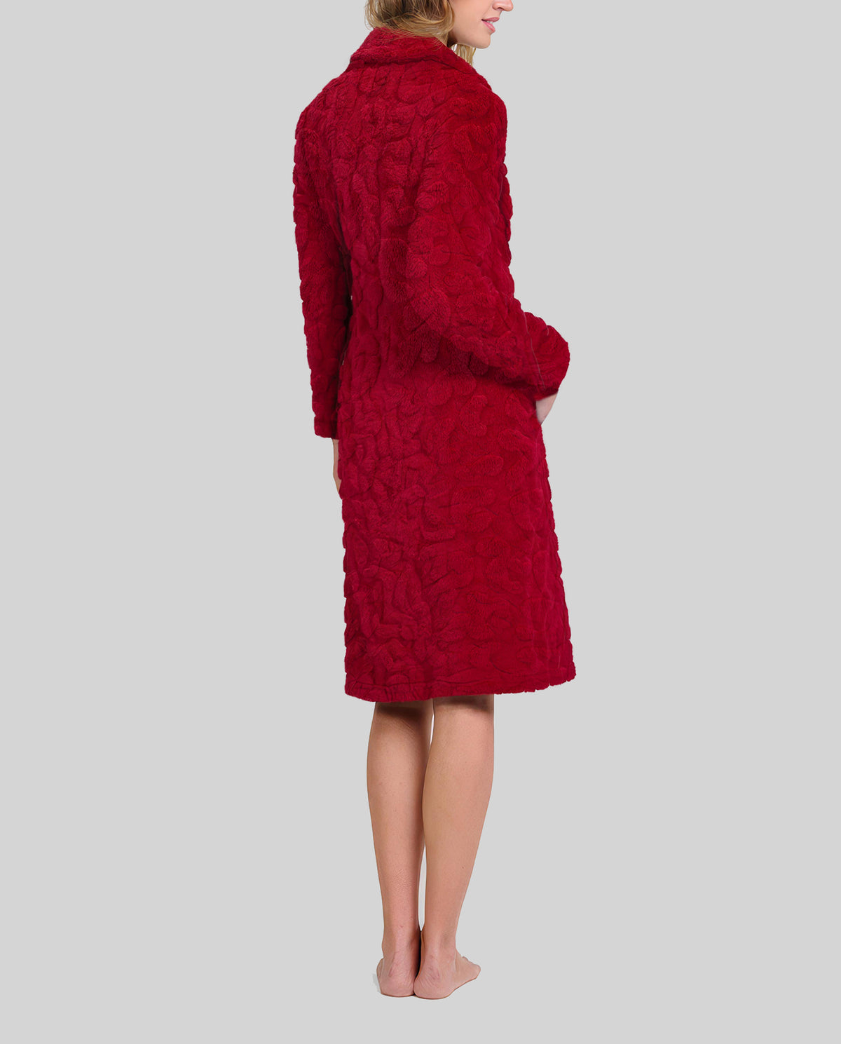 Mujer de espaldas luce bata abotonada y con bolsillos en jacquard granate para el invierno