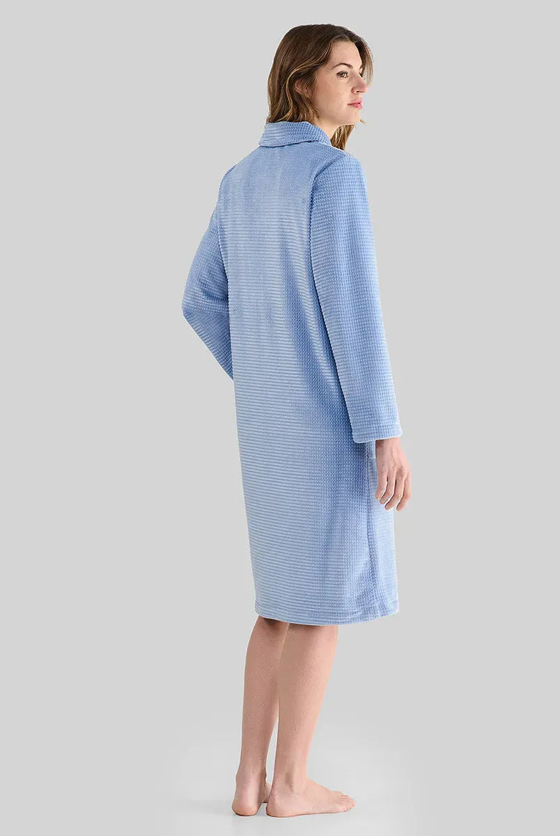 Mujer de espaldas luce bata larga de invierno jacquard azul con bolsillos