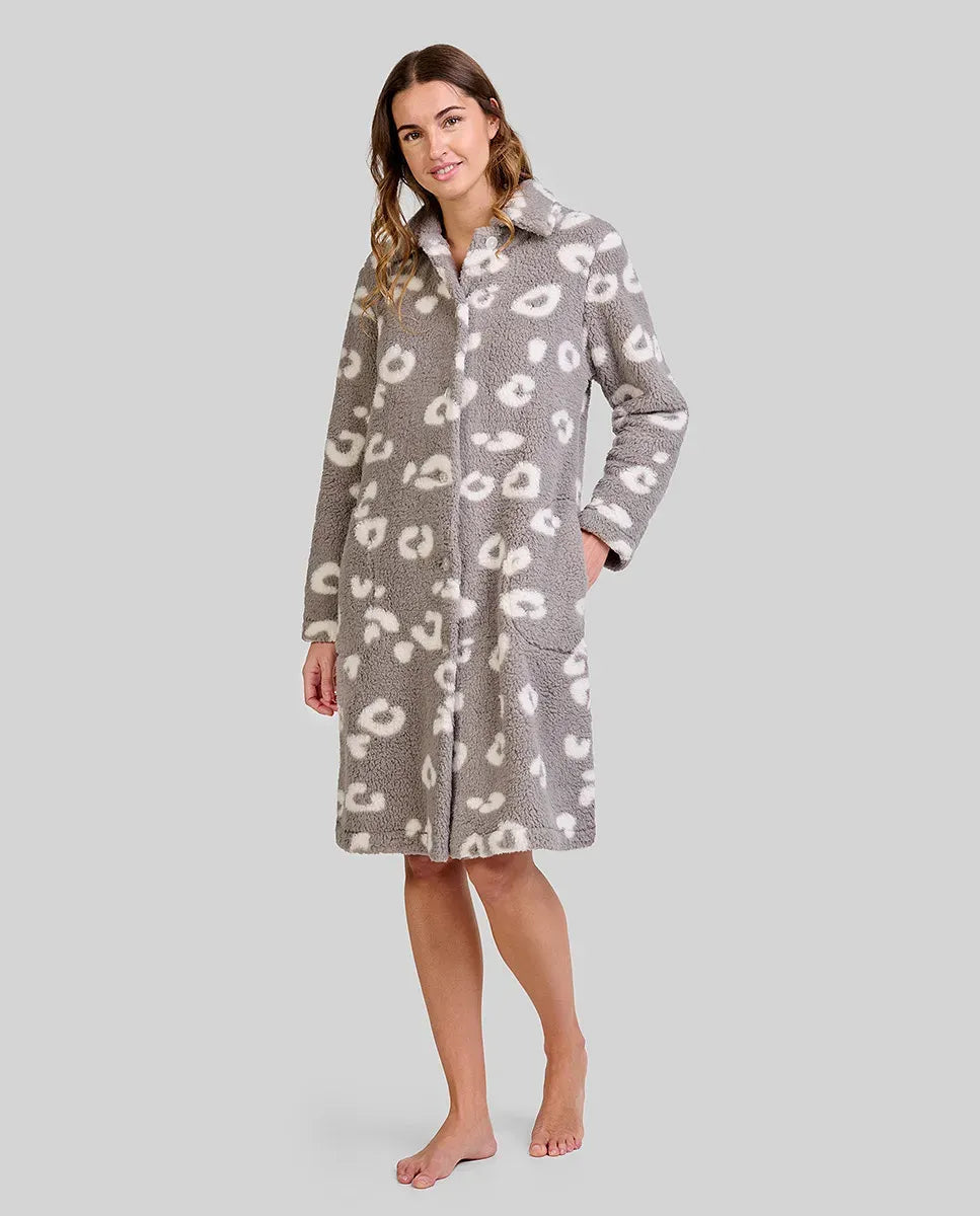 Mujer luce bata polar gris hasta la rodilla con patrones animales blancos y dos bolsillos