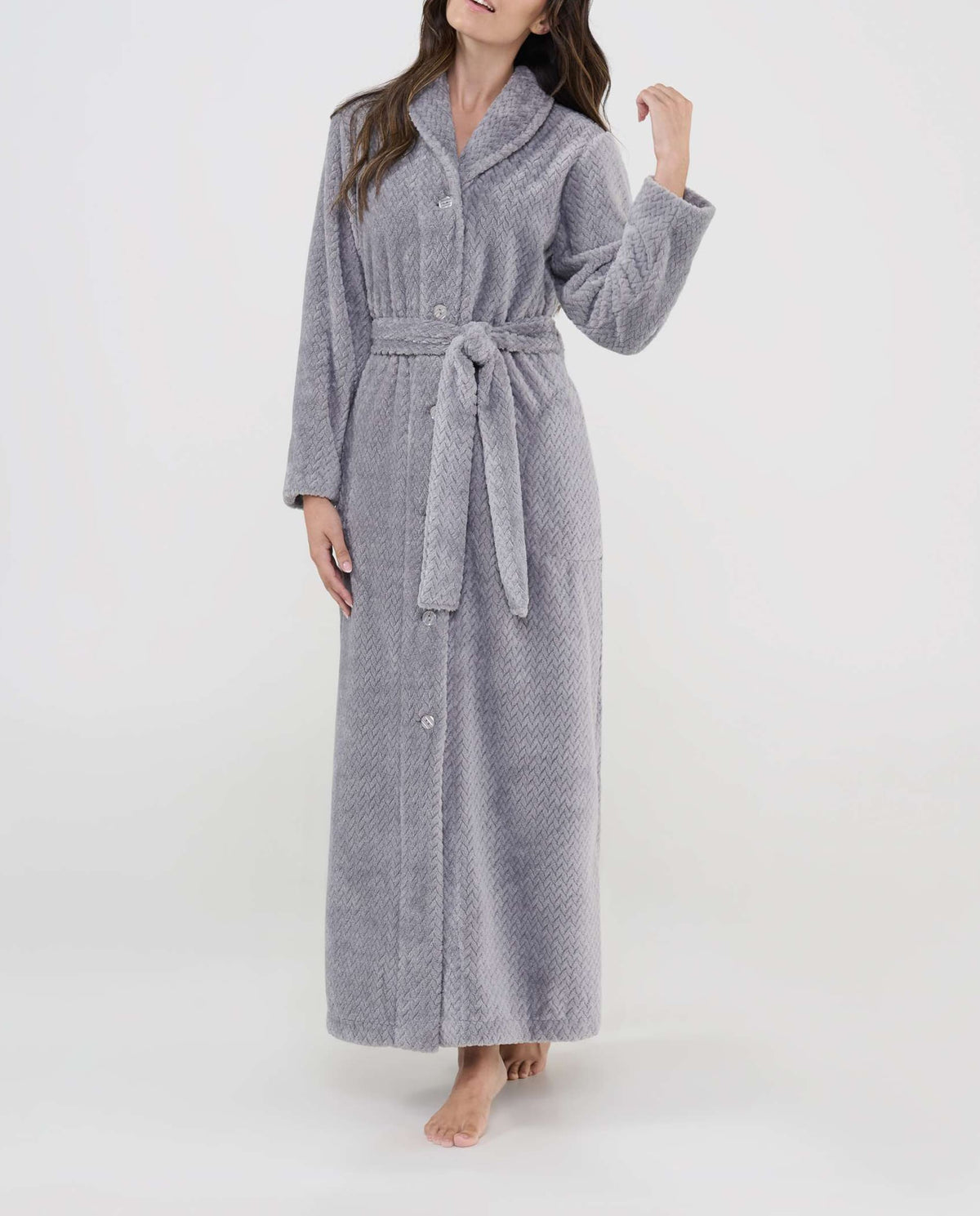 Mujer luce bata larga gris jacquard con botones, cinturón y bolsillos laterales