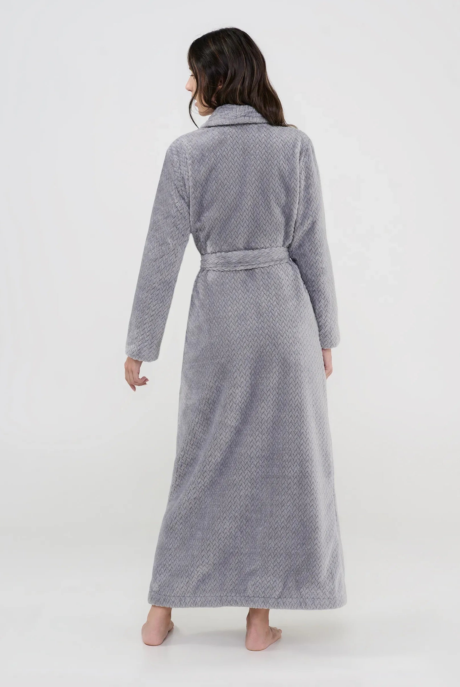 Mujer de espaldas con bata larga gris textura espiga con cinturón ideal para hogar.