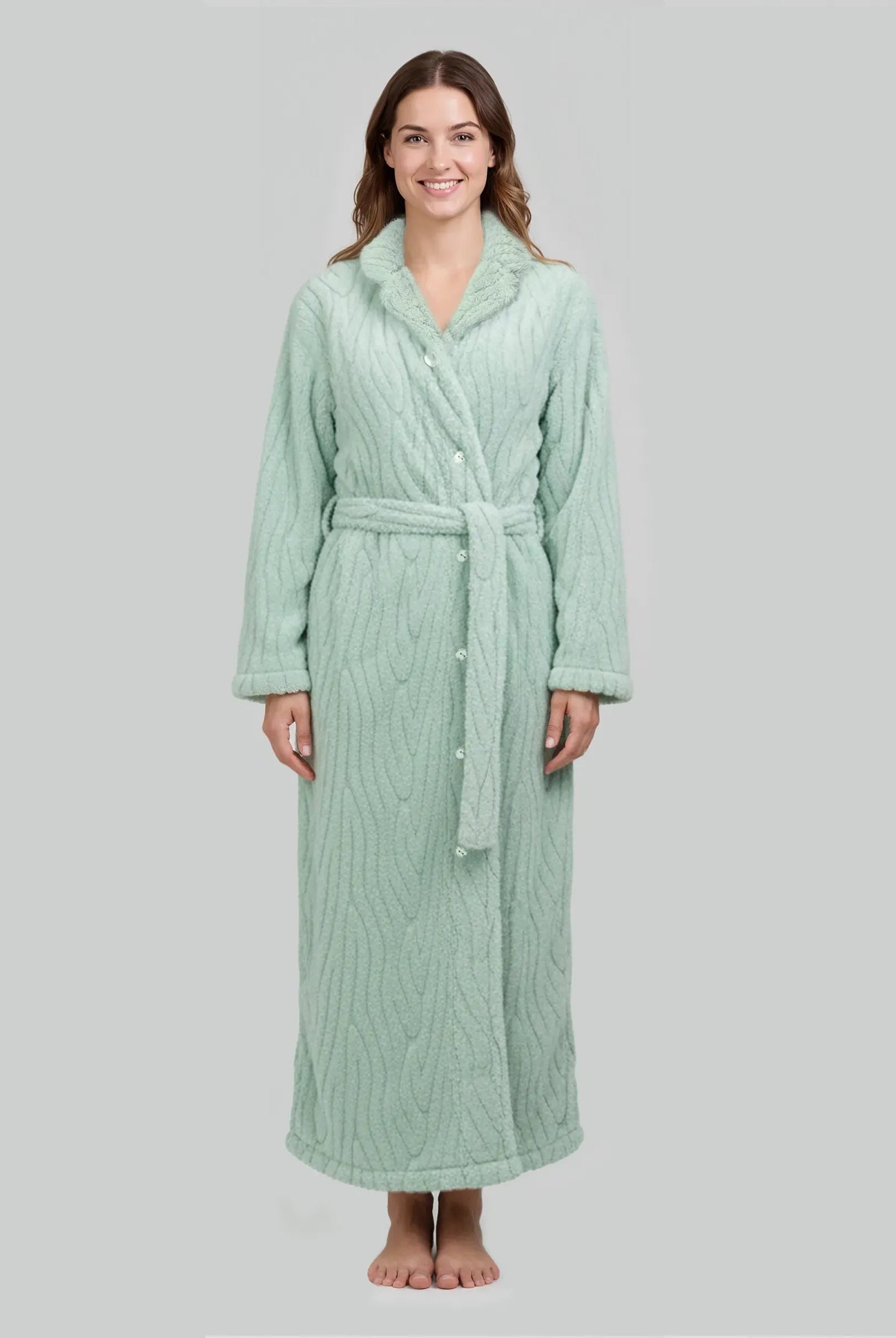 Mujer luce bata larga verde claro con textura, abotonada mas cinturón y bolsillos