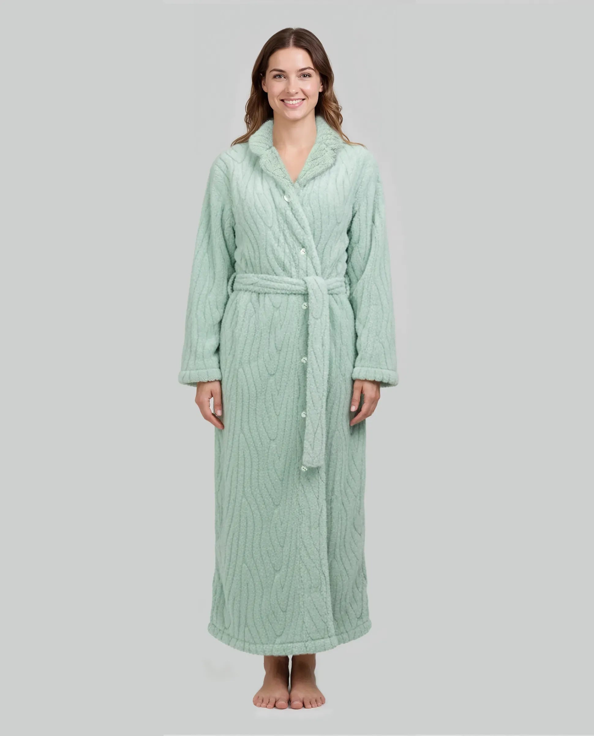 Mujer luce bata larga verde claro con textura, abotonada mas cinturón y bolsillos