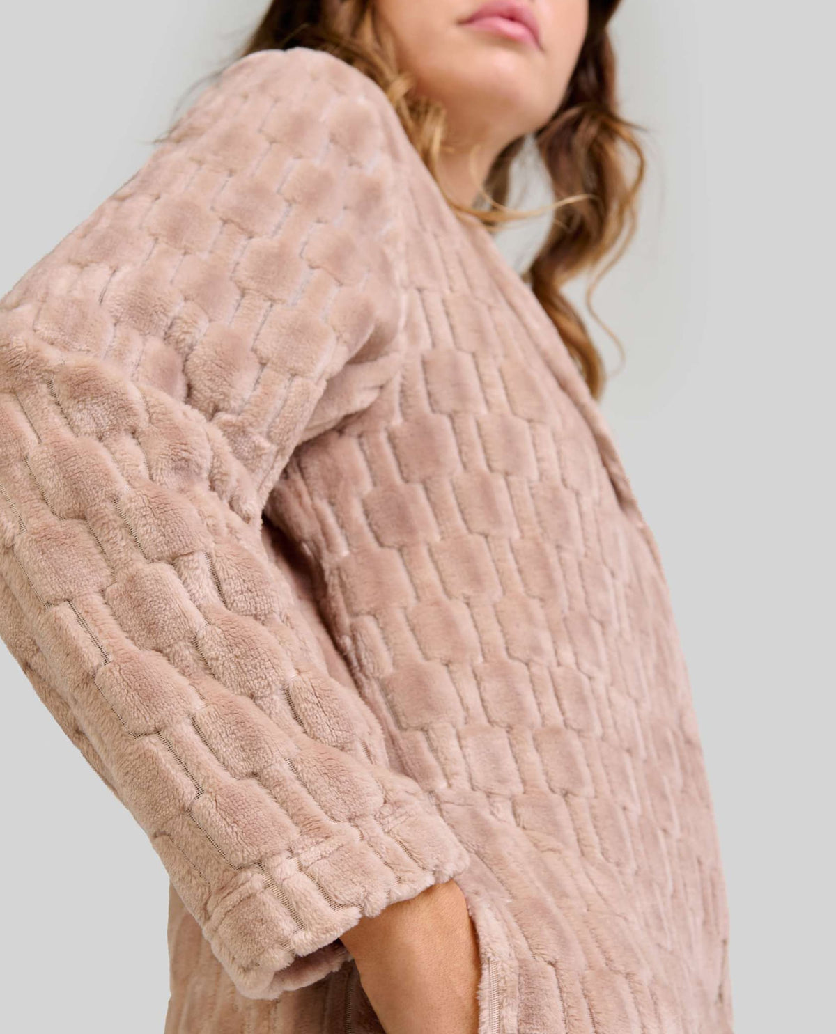 Mujer luce bata de invierno Jacquard camel de manga larga con bolsillos y sutil patrón geométrico