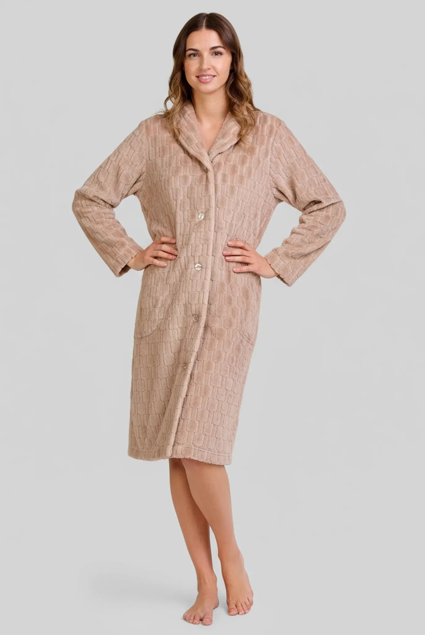 Mujer posa con elegante bata abotonada color camel hasta la rodilla