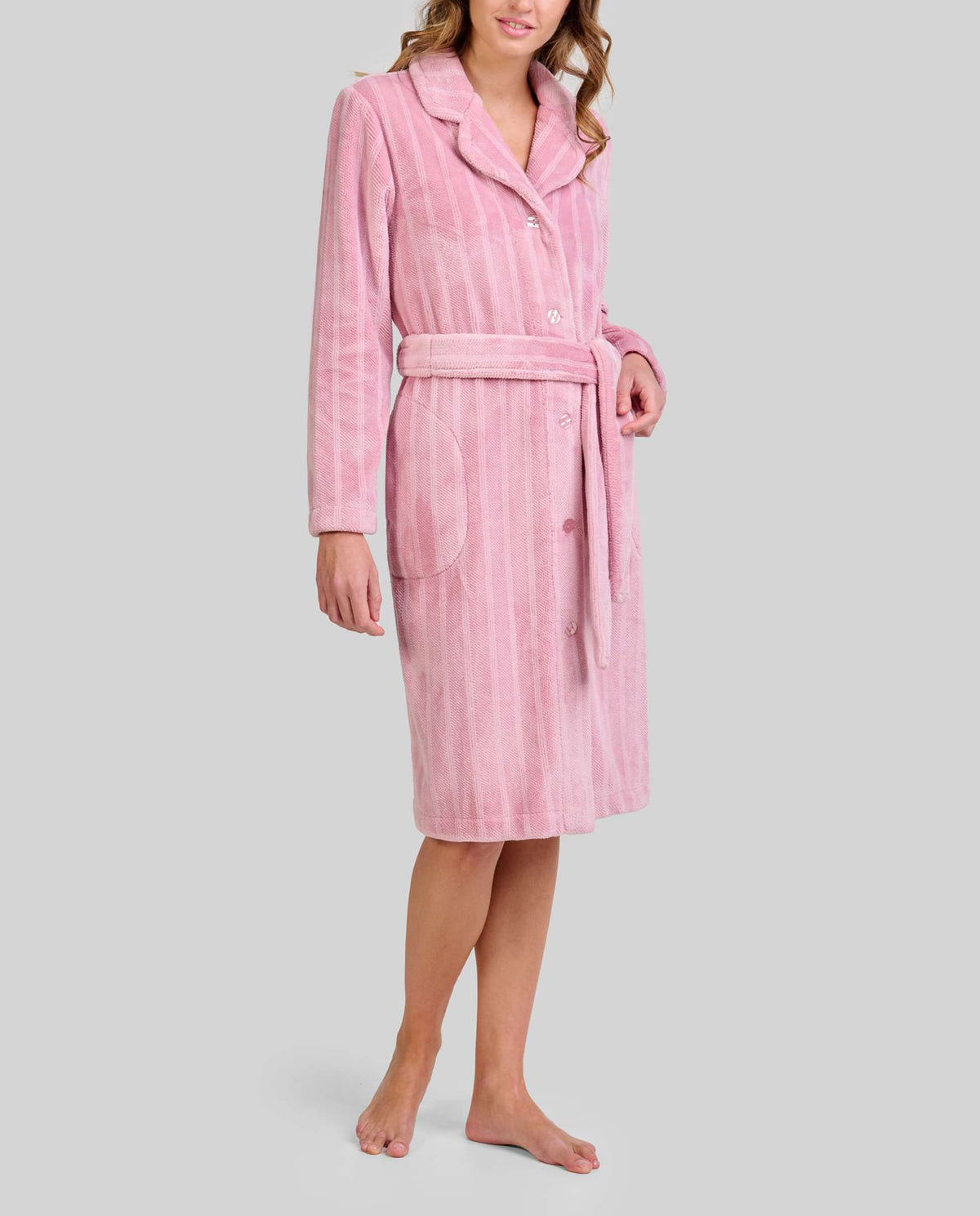 Detalle de bata larga de invierno en amoroso tejido jacquard rosa con botones y cinturón