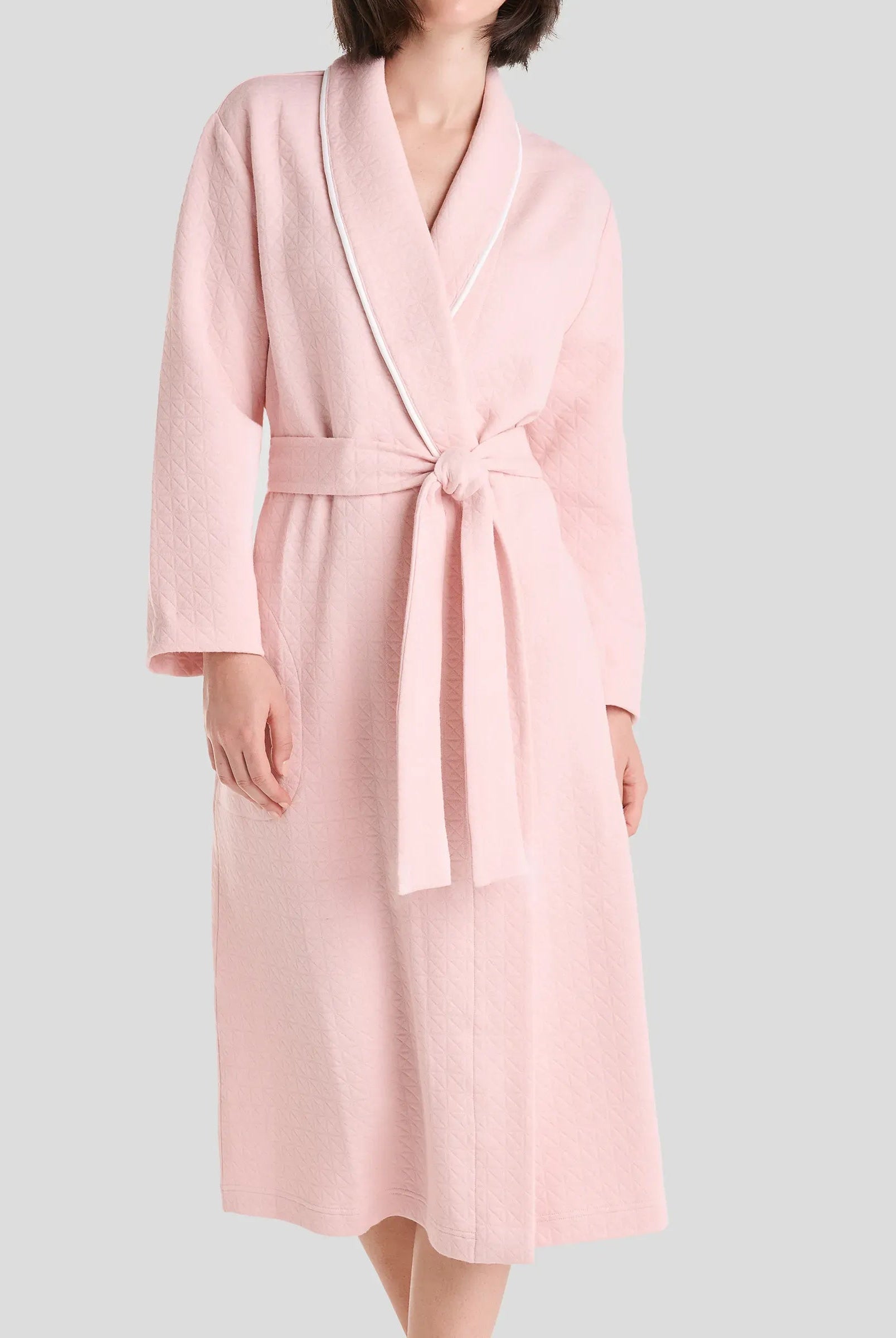 Vista detalle del cuello de la bata de verano cruzada en viscosa rosa a topitos con vivo en tira de cuello y manga francesa.