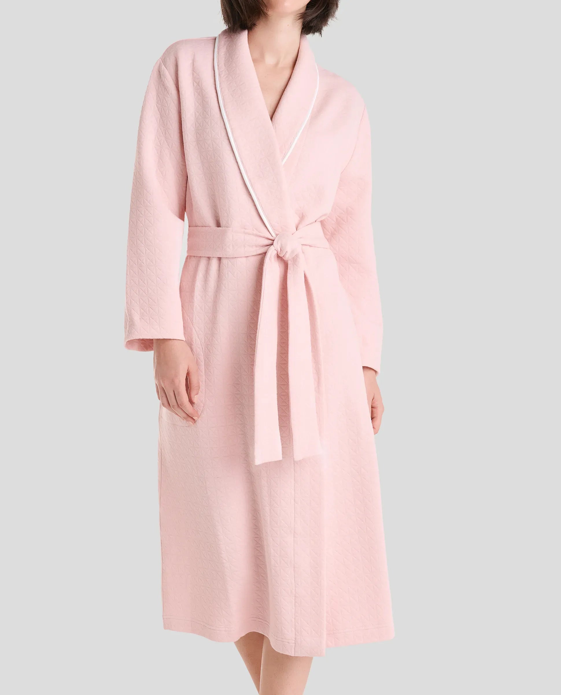Vista detalle del cuello de la bata de verano cruzada en viscosa rosa a topitos con vivo en tira de cuello y manga francesa.