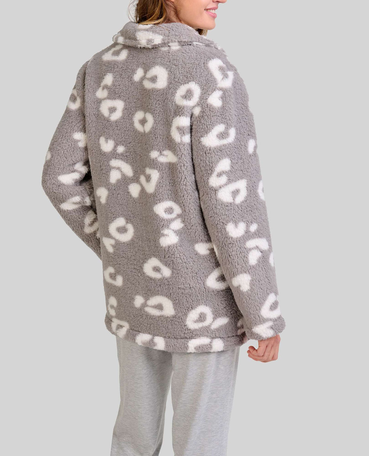 Mujer de espaldas con bata polar gris y blanca de leopardo y pantalón de pijama gris