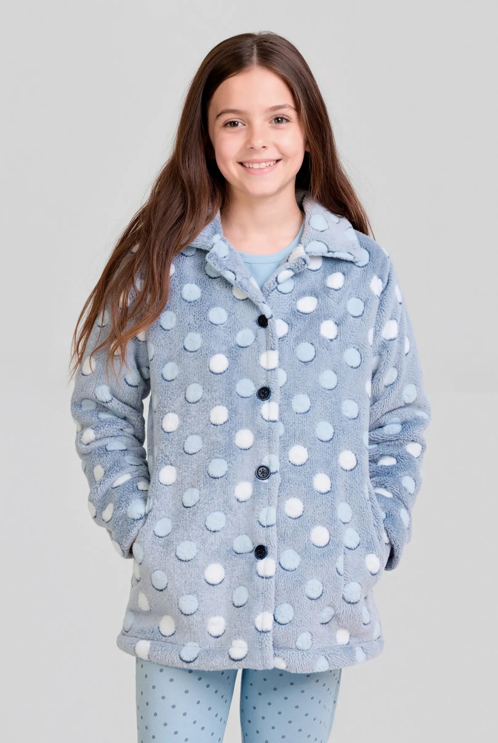 Niña vistiendo amorosa bata de invierno para casa abotonada estampado azul con círculos en relieve y con bolsillos