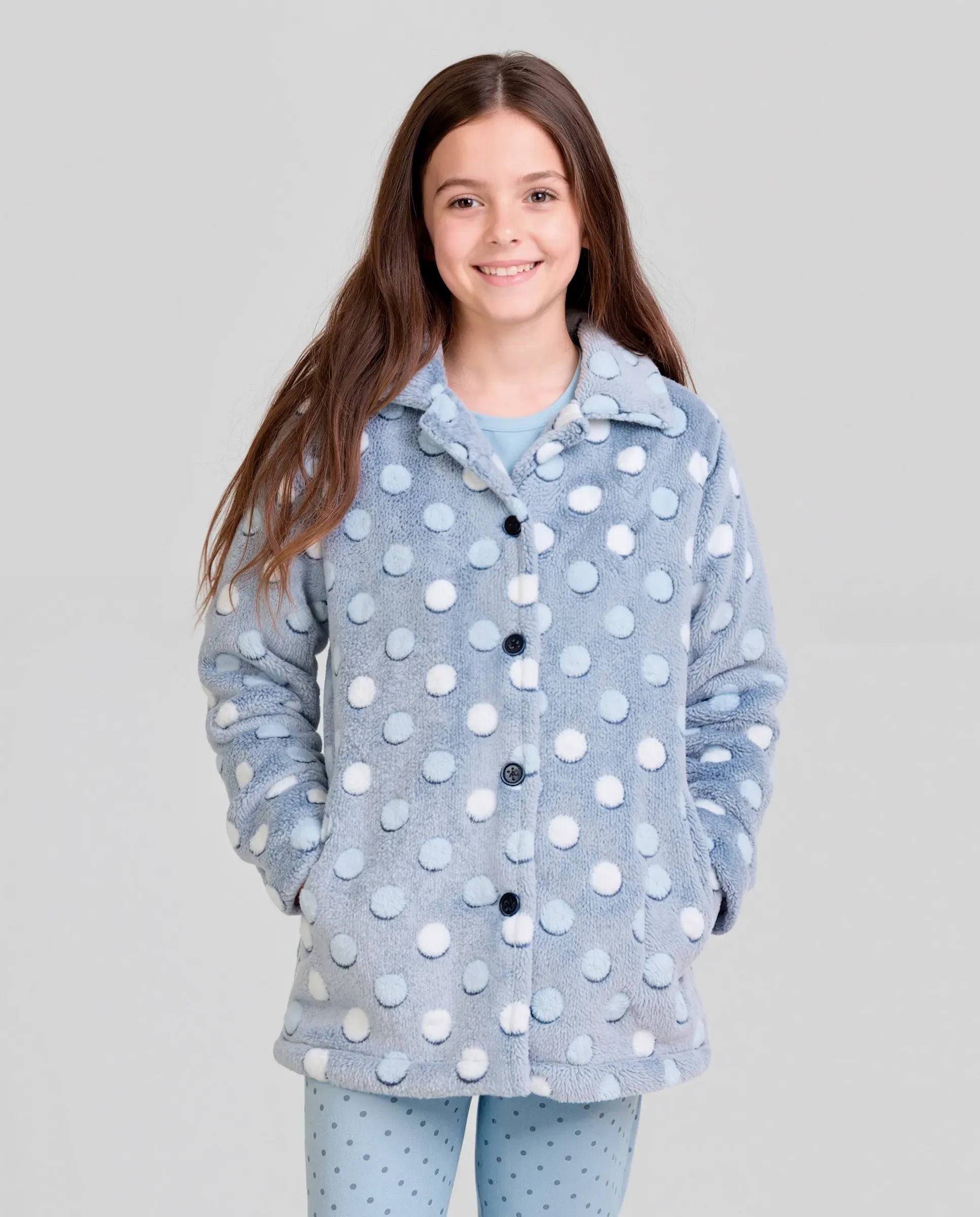 Niña vistiendo amorosa bata de invierno para casa abotonada estampado azul con círculos en relieve y con bolsillos