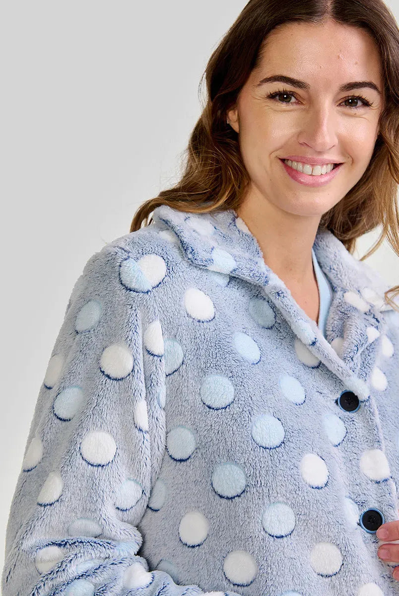 Mujer luce suave bata de invierno corta abotonada en azul claro con lunares