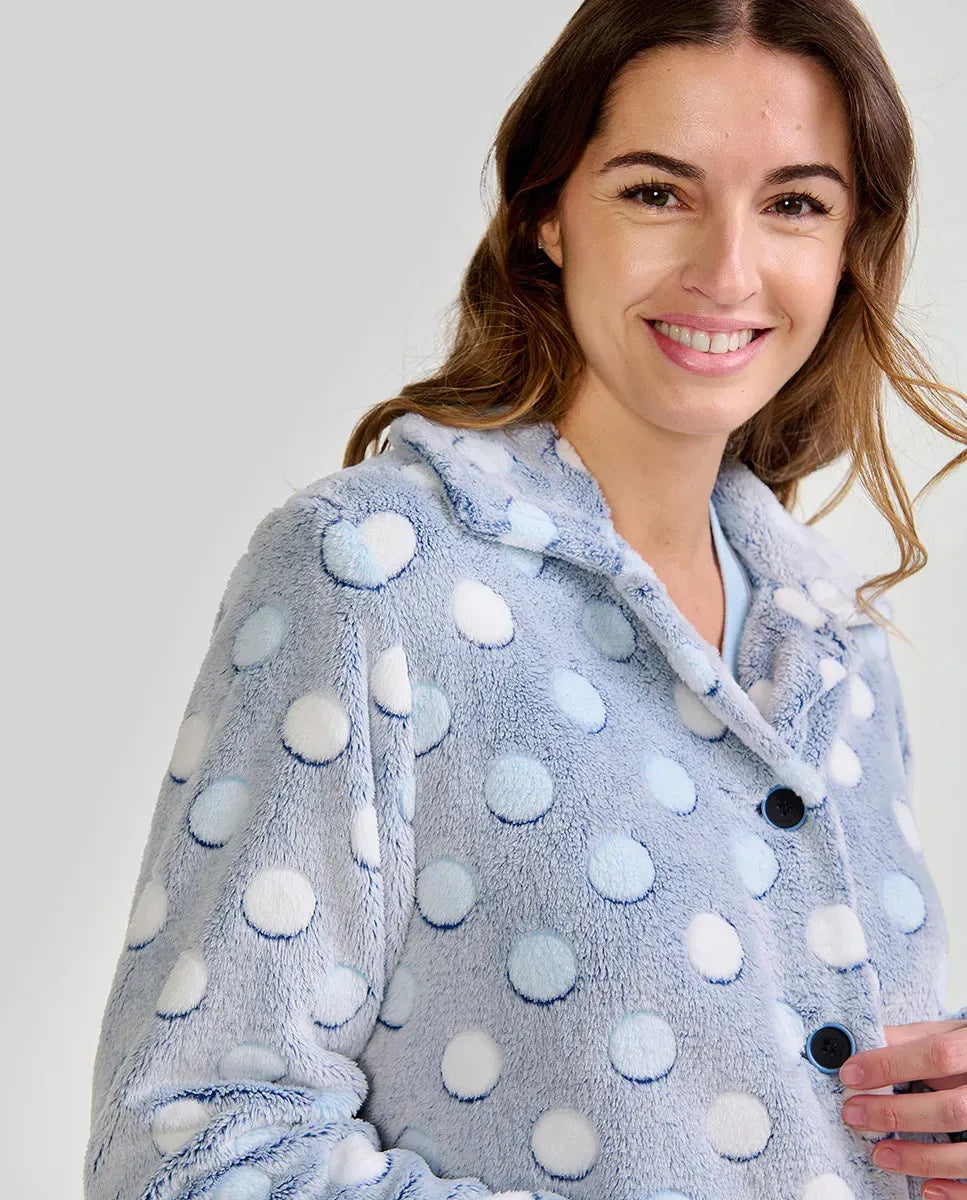 Mujer luce suave bata de invierno corta abotonada en azul claro con lunares
