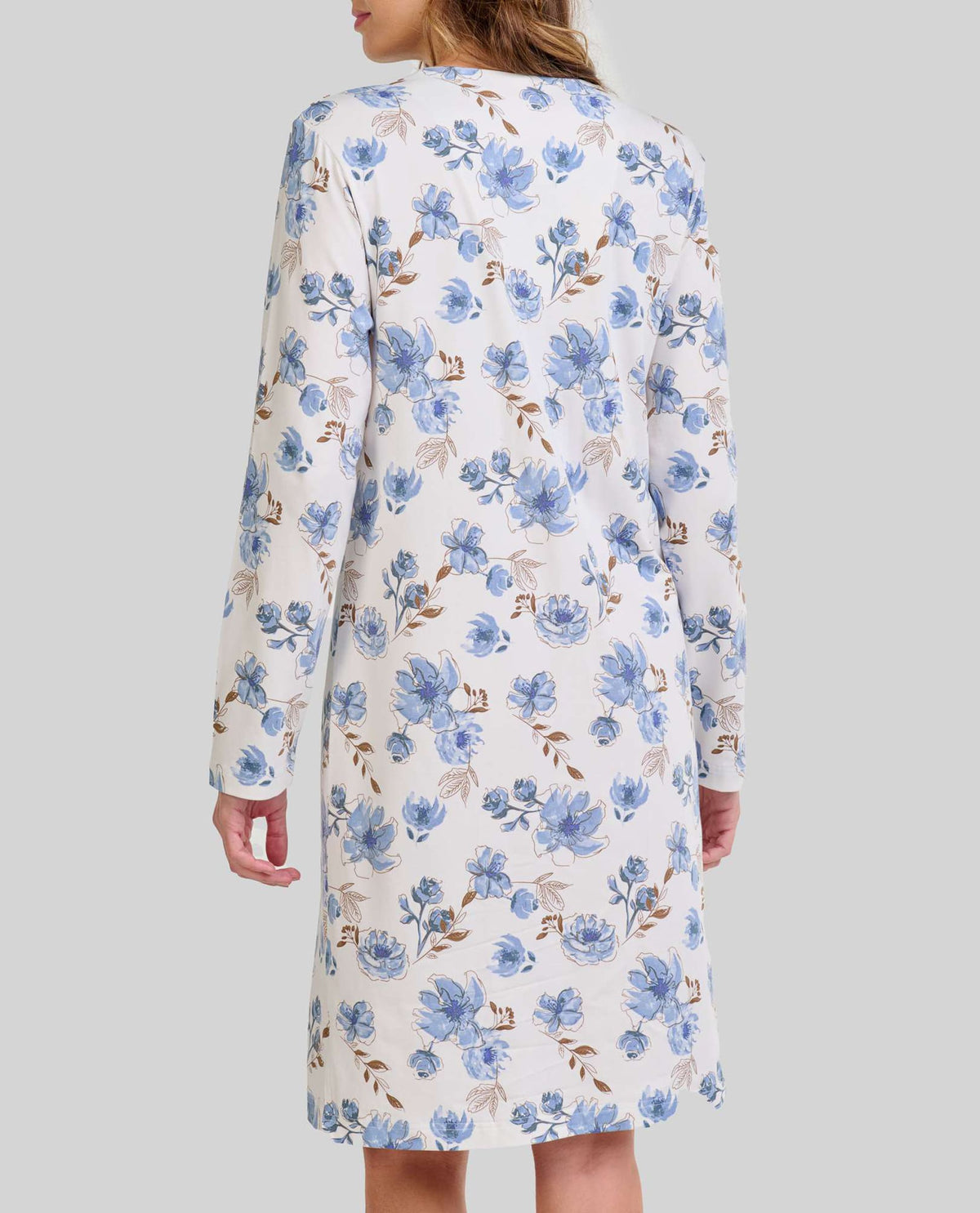 Mujer de espaldas luce camisón blanco de flores azules y beige hasta la rodilla con manga larga