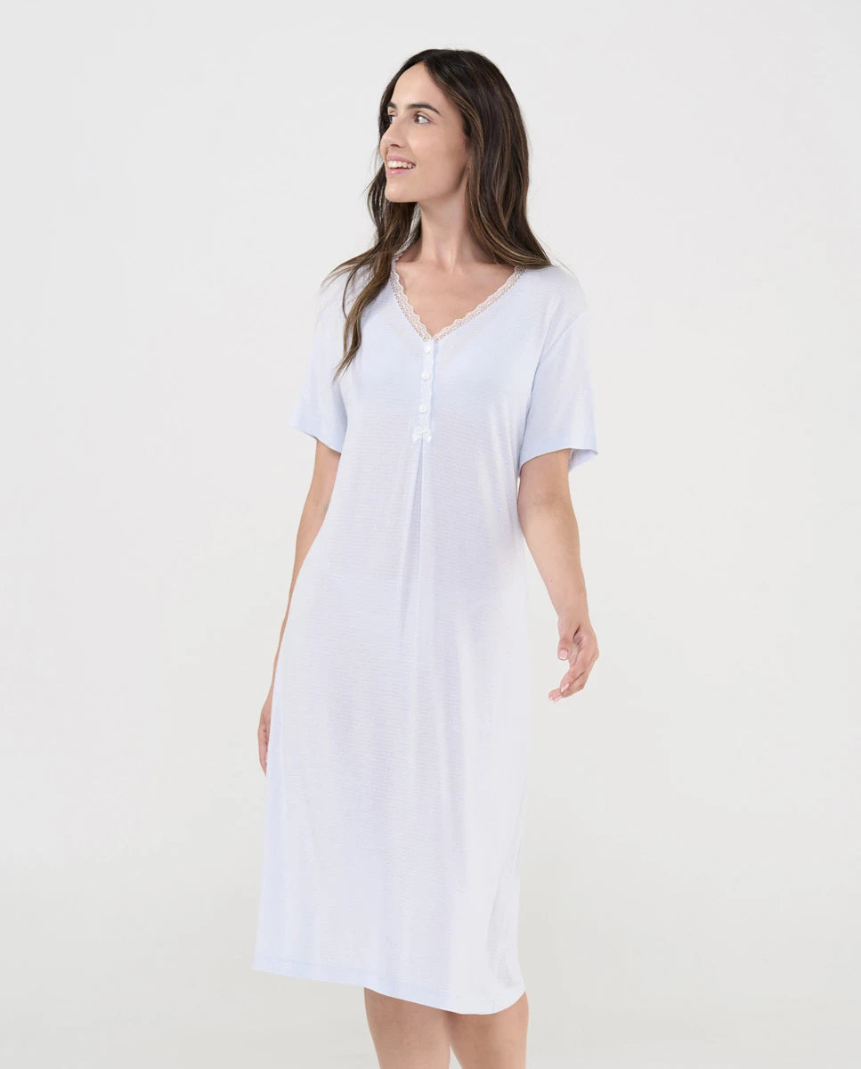 Mujer luce camisón lencero marfil de manga corta cuello pico con botones, puntilla y lacito de raso decorativo.