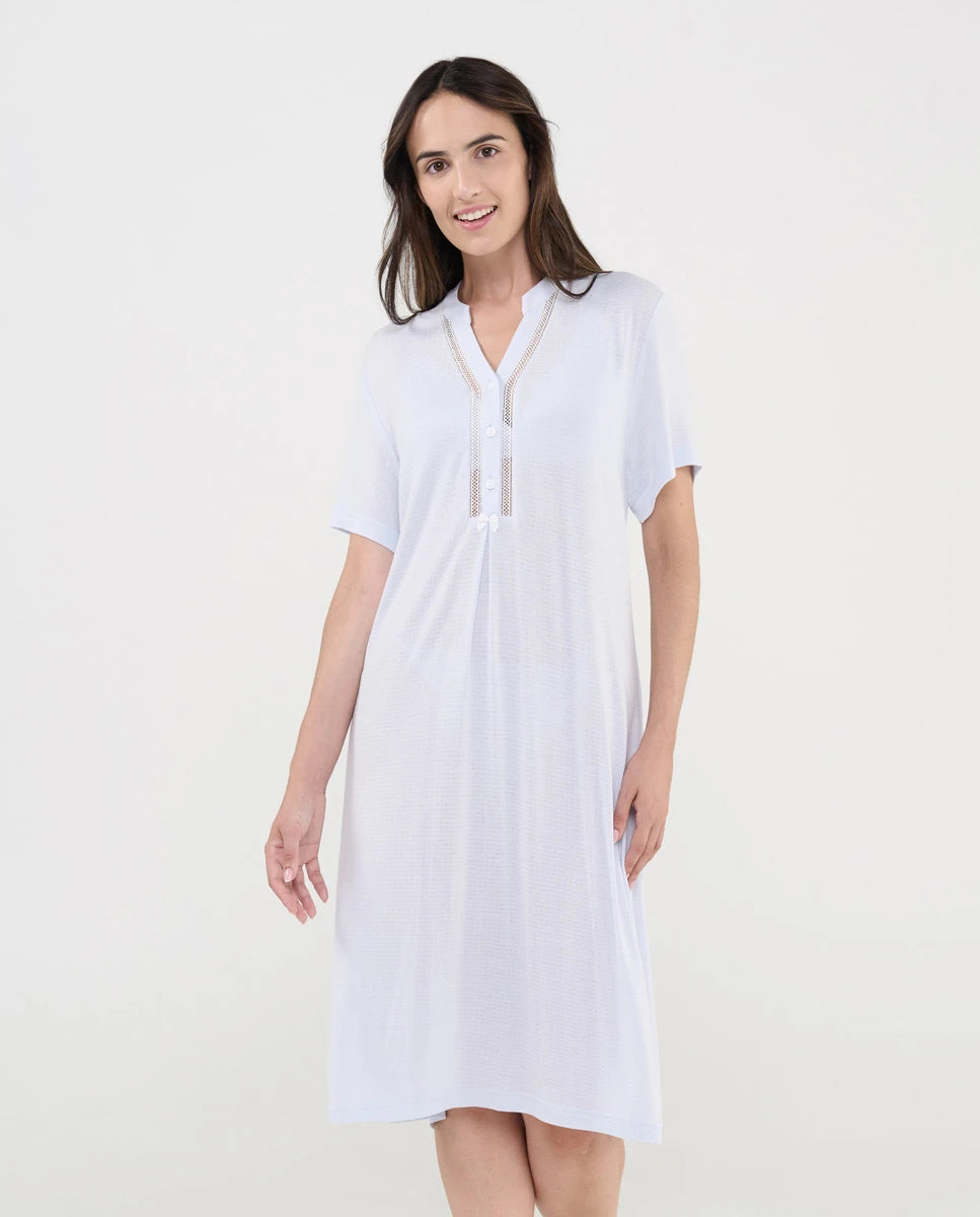Mujer luce camisón lencero celeste de manga corta y escote en V con botones y entredós