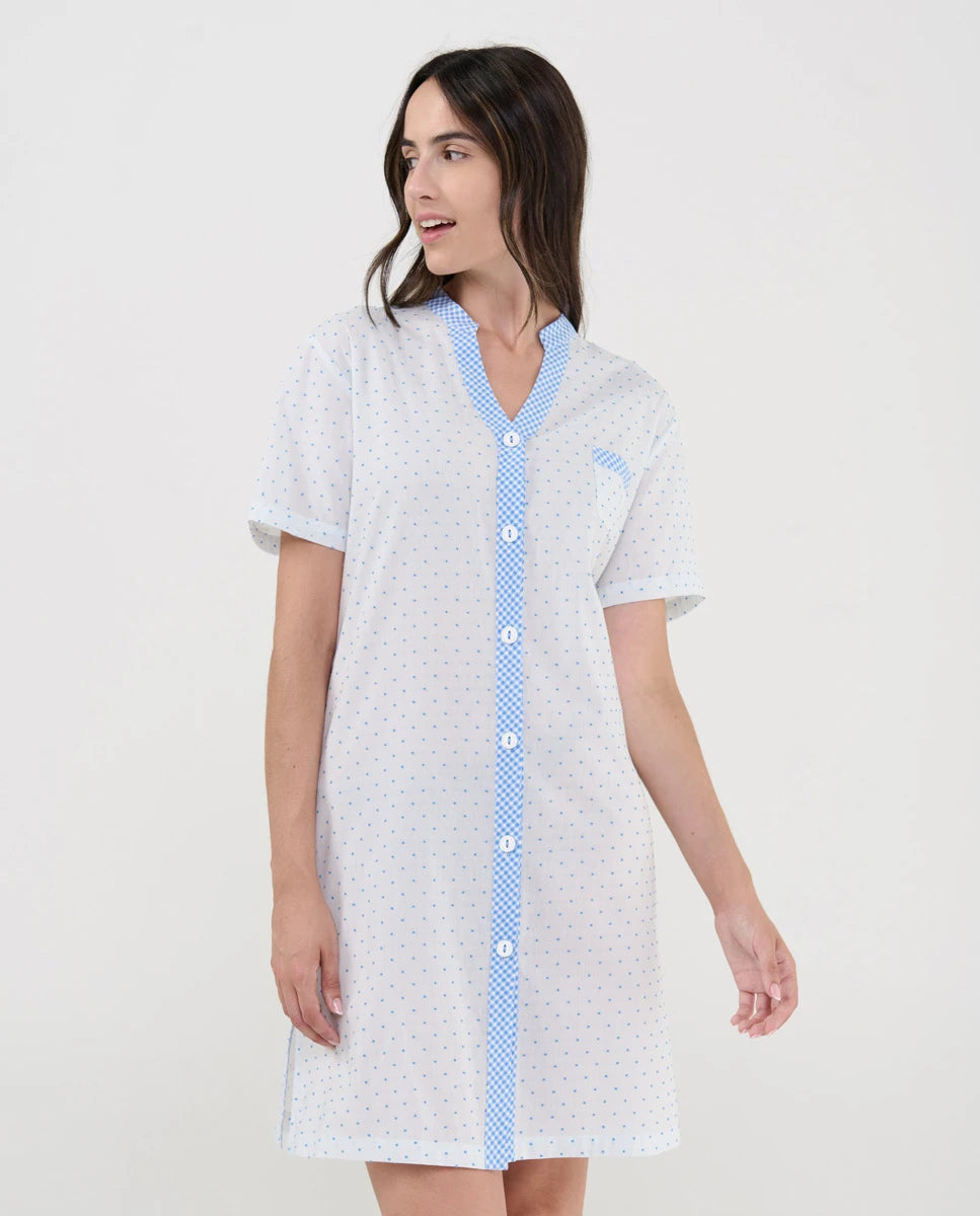 Mujer con camisón blanco plumeti celeste abierto con botones frontales y bolsillo decorativo.