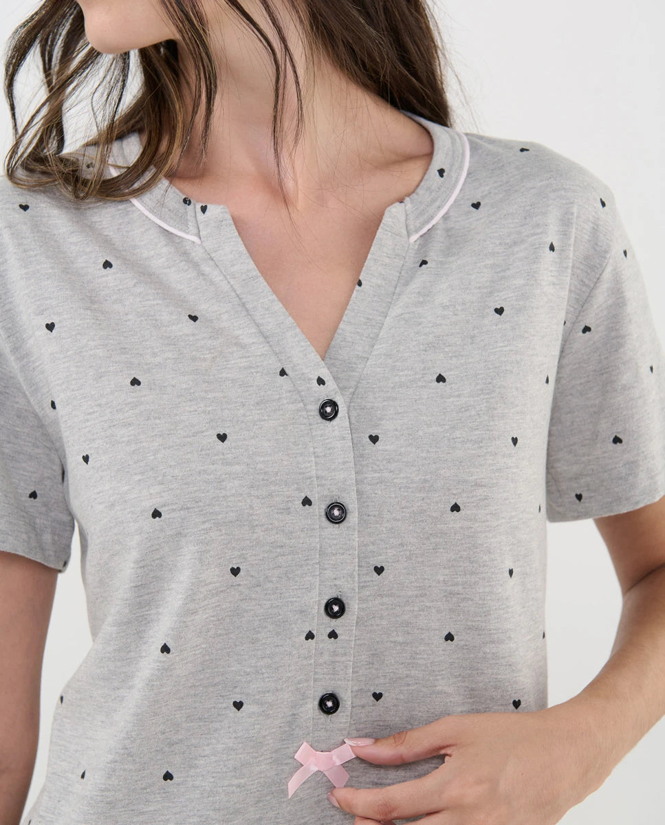 Detalle del camisón de manga corta gris con escote pico abierto con botones y lazo decorativo de raso rosa.
