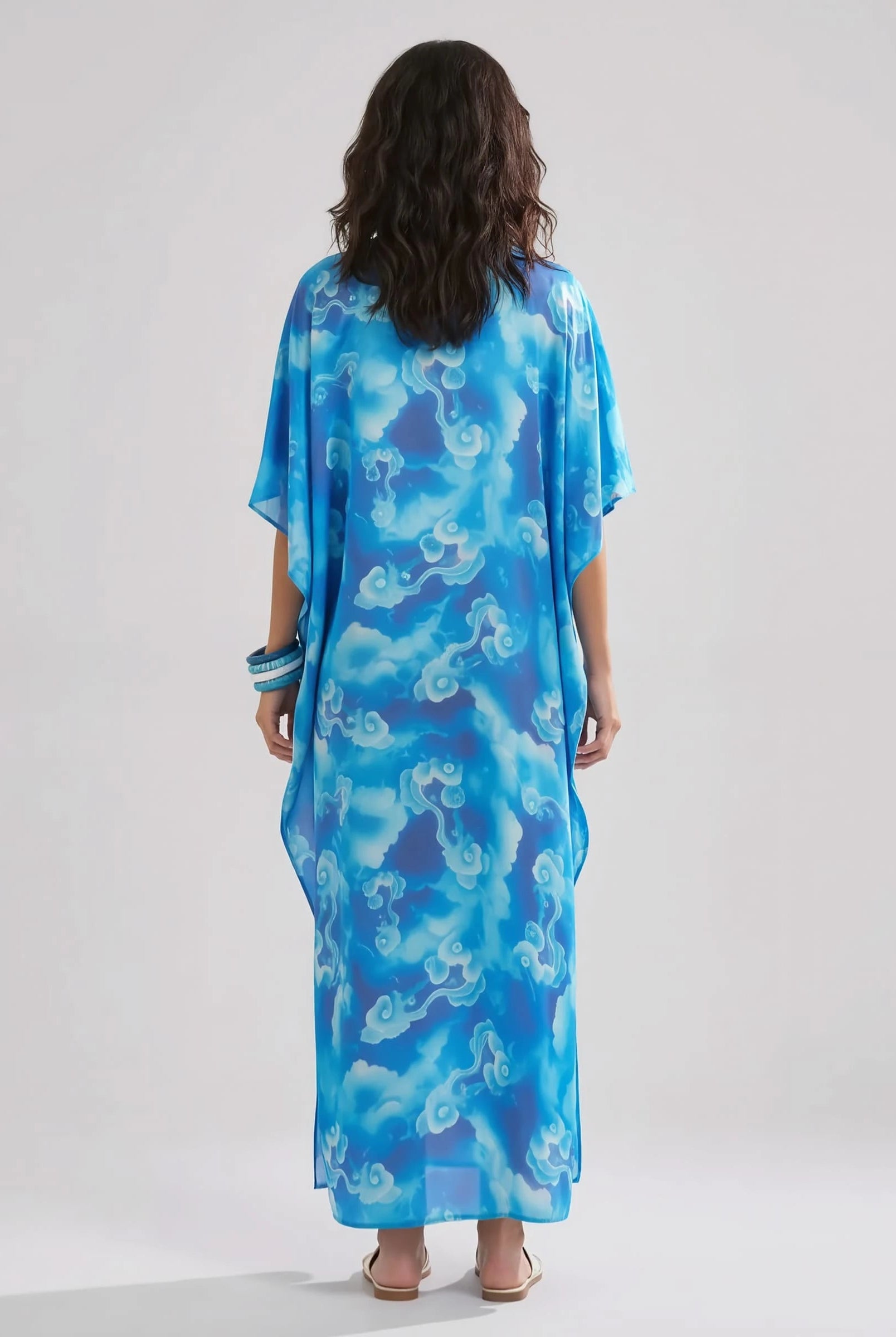 Mujer de espaldas con kaftan de seda natural largo estampado azul