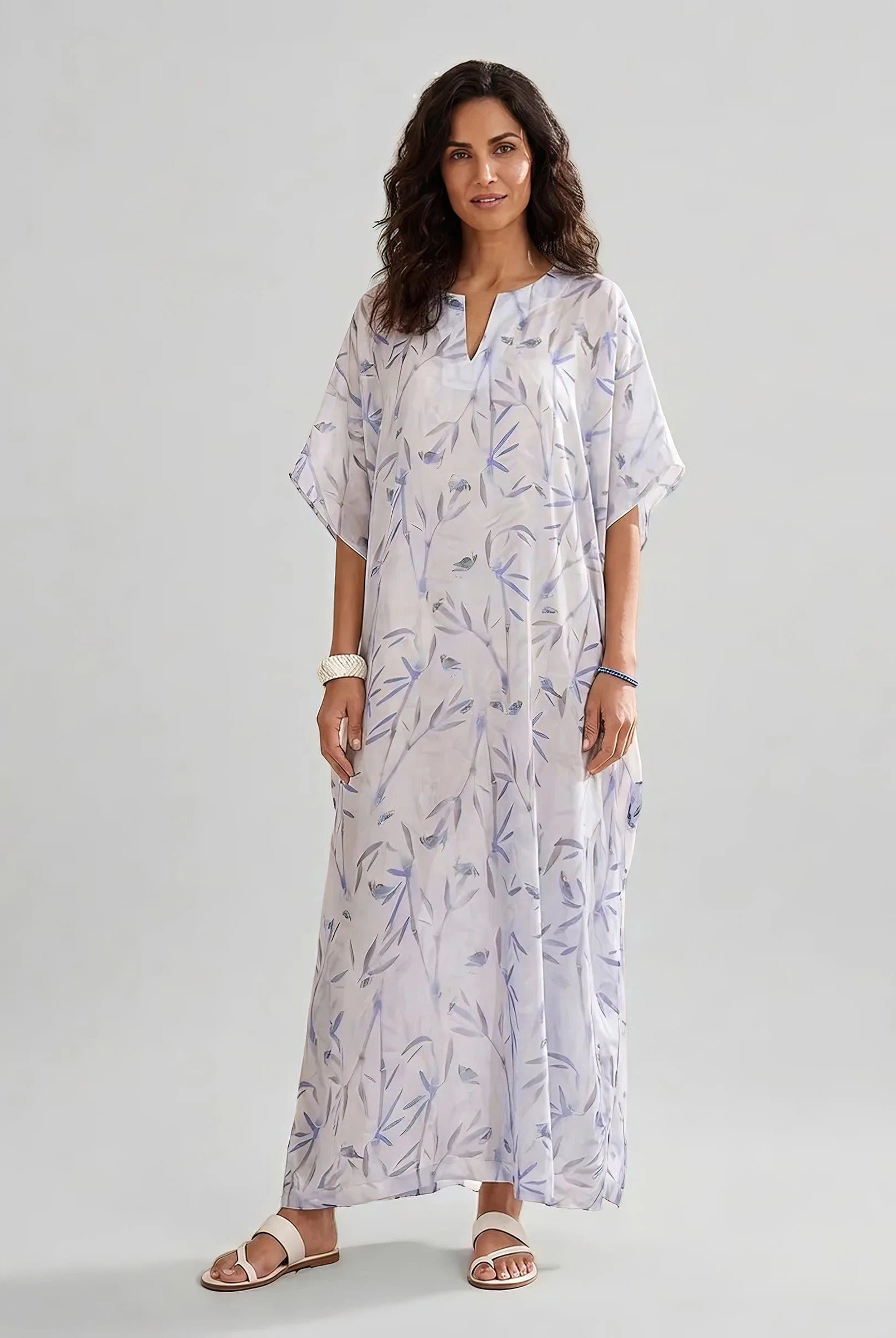 Mujer viste caftan de seda natural estampado con escote redondo y abertura central con manga mariposa al codo