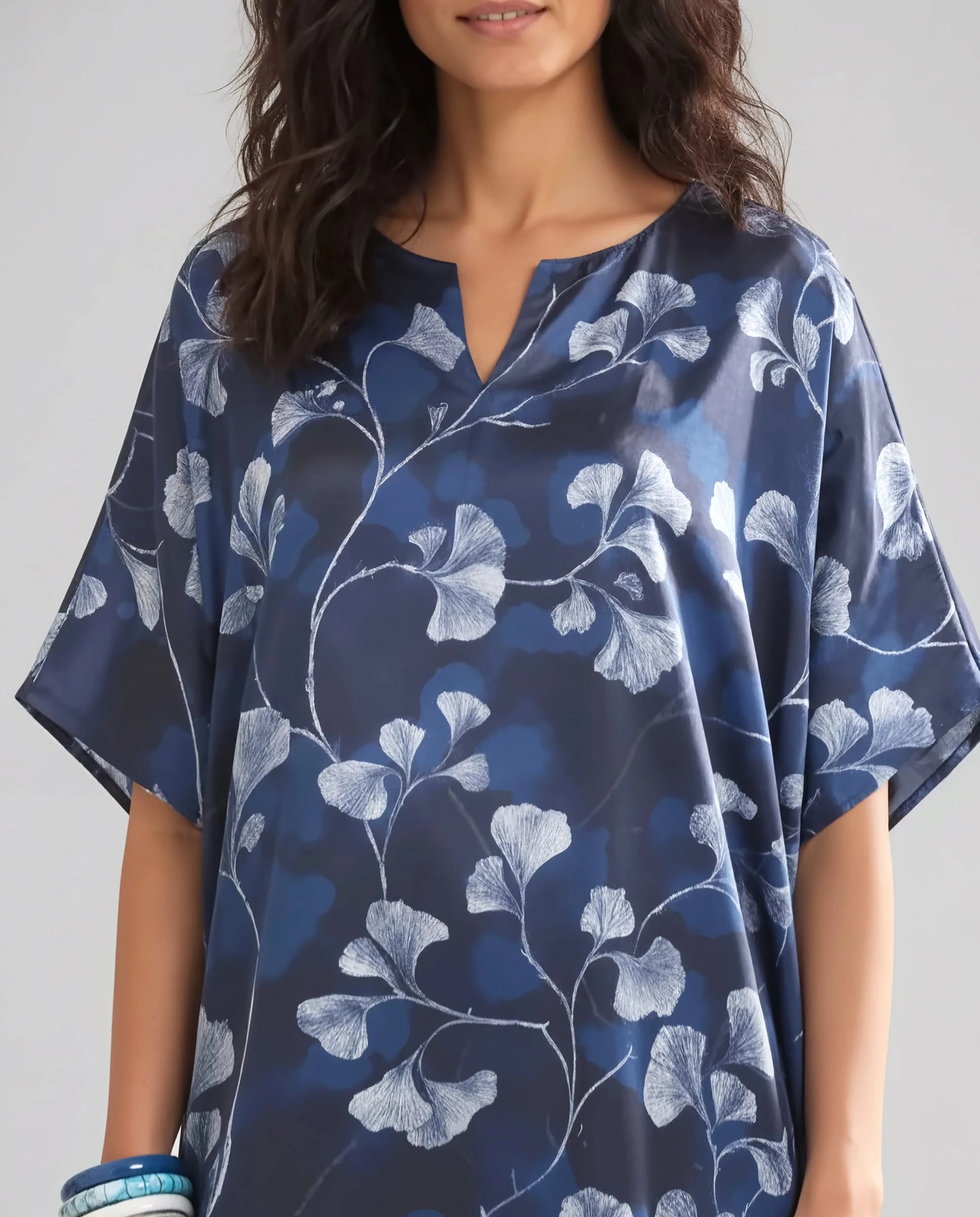 Vista detalle mujer con kaftan azul marino con estampado floral blanco y cuello en V