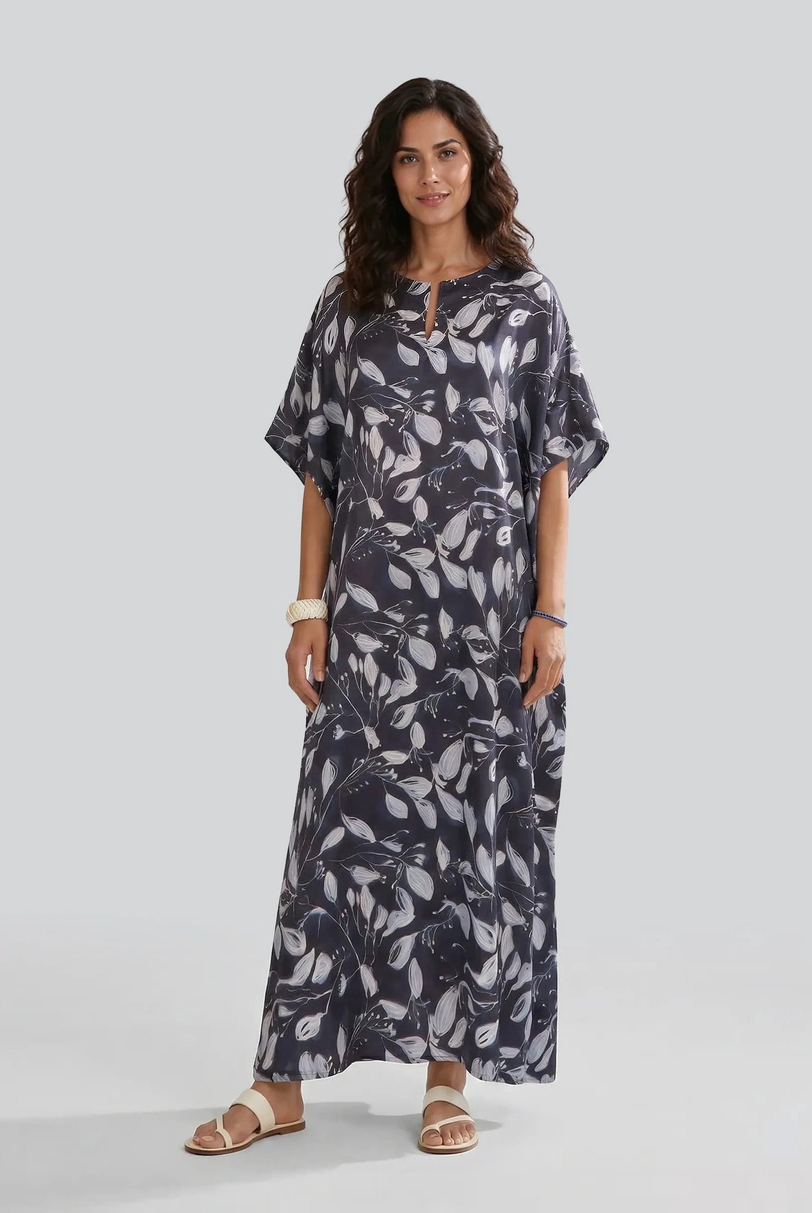 Mujer posa con kaftan largo de verano de seda natural marino con estampado de flores blancas
