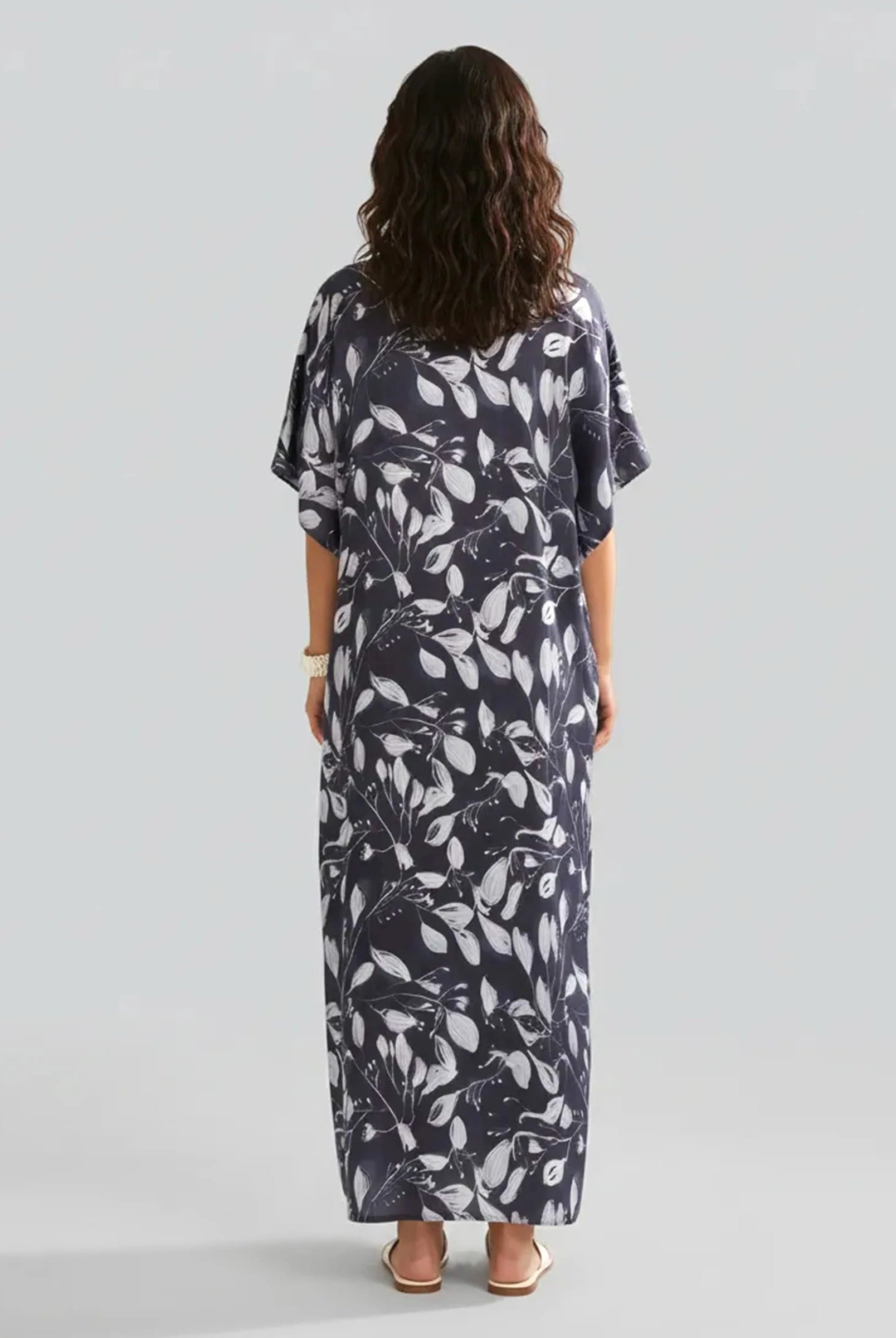 Mujer de espaldas con kaftan marino largo hasta los tobillos color marino con flores