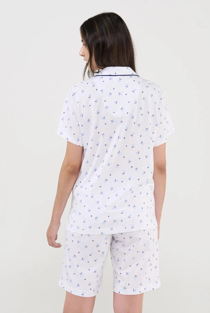 Vista de espaldas de mujer con pijama de verano corto blanco estampado cerecitas marino