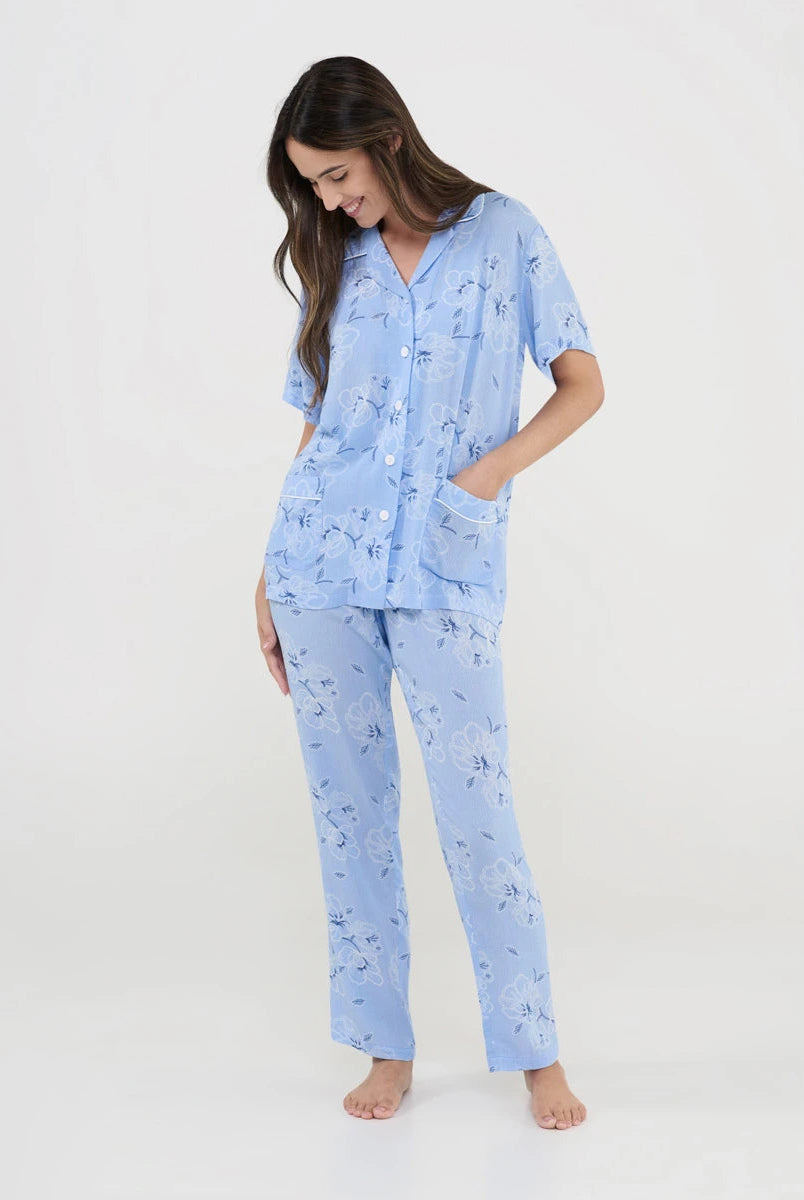 Mujer con pijama de verano celeste de manga corta abierto con solapa y botones. Pantalón largo a juego
