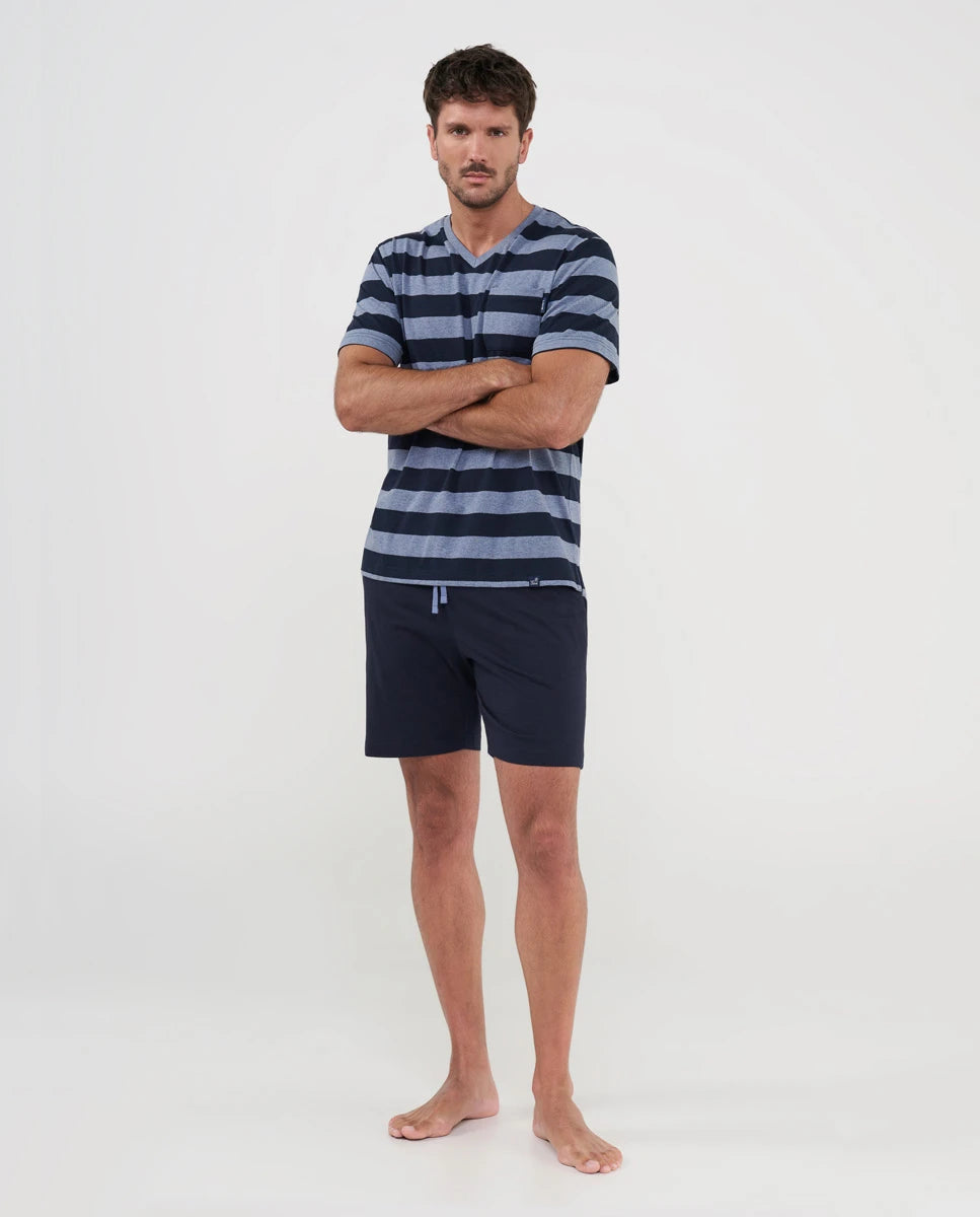 Hombre posa con pijama corto de verano con top marino a rayas y pantalón liso marino