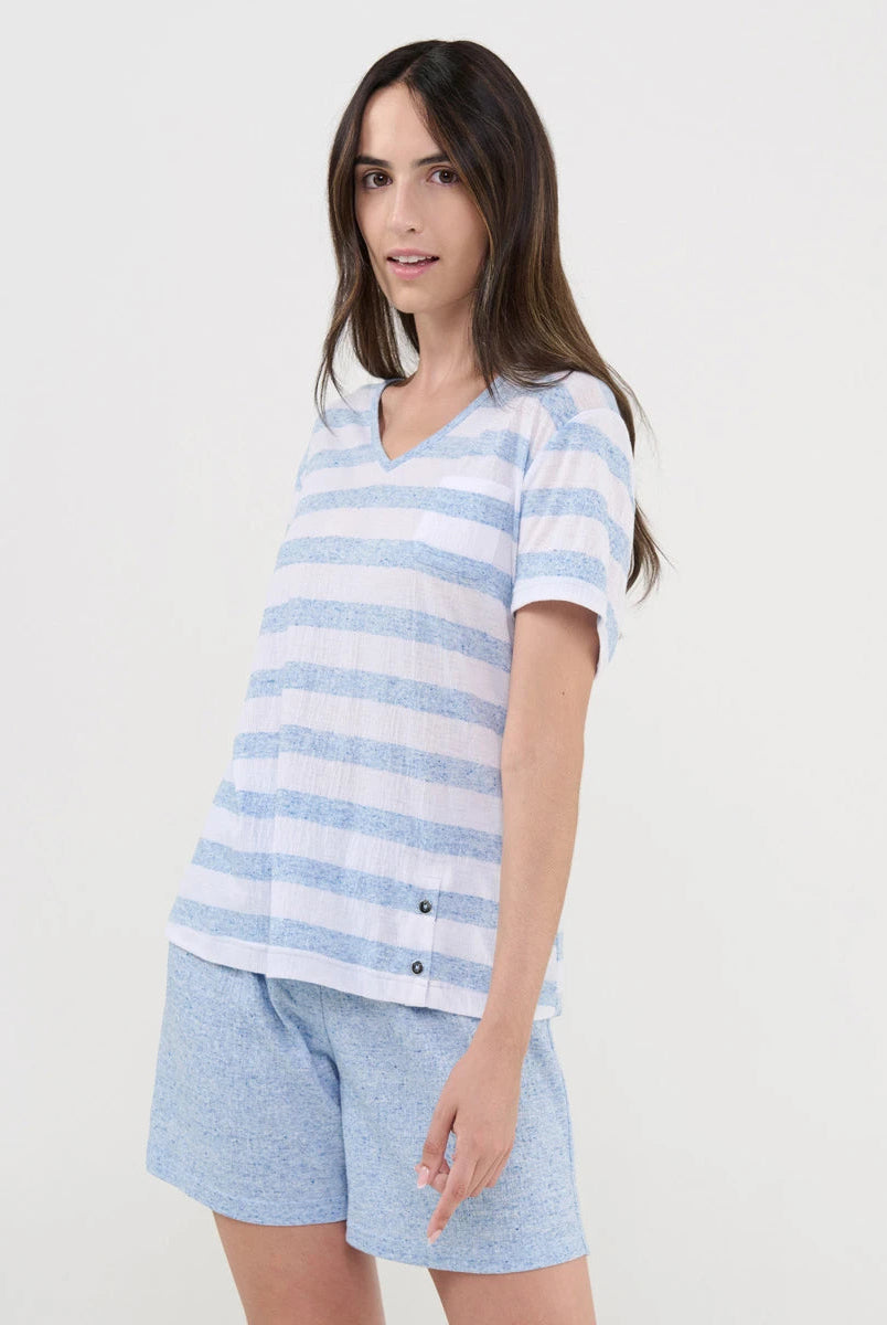 Mujer viste pijama corto de verano con camiseta de rayas celeste y cuello pico y pantalón liso a juego
