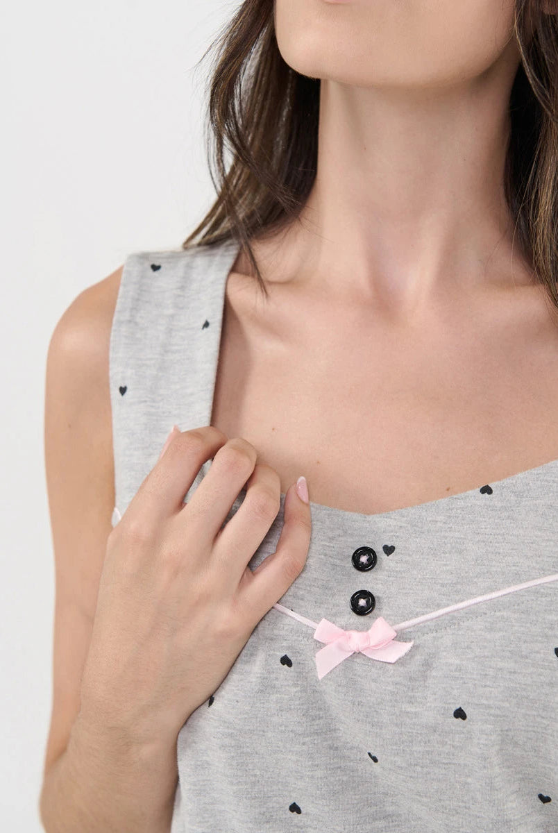 Detalle del escote con botones decorativos, vivo y lazo de raso rosa del top de pijama de tirante ancho