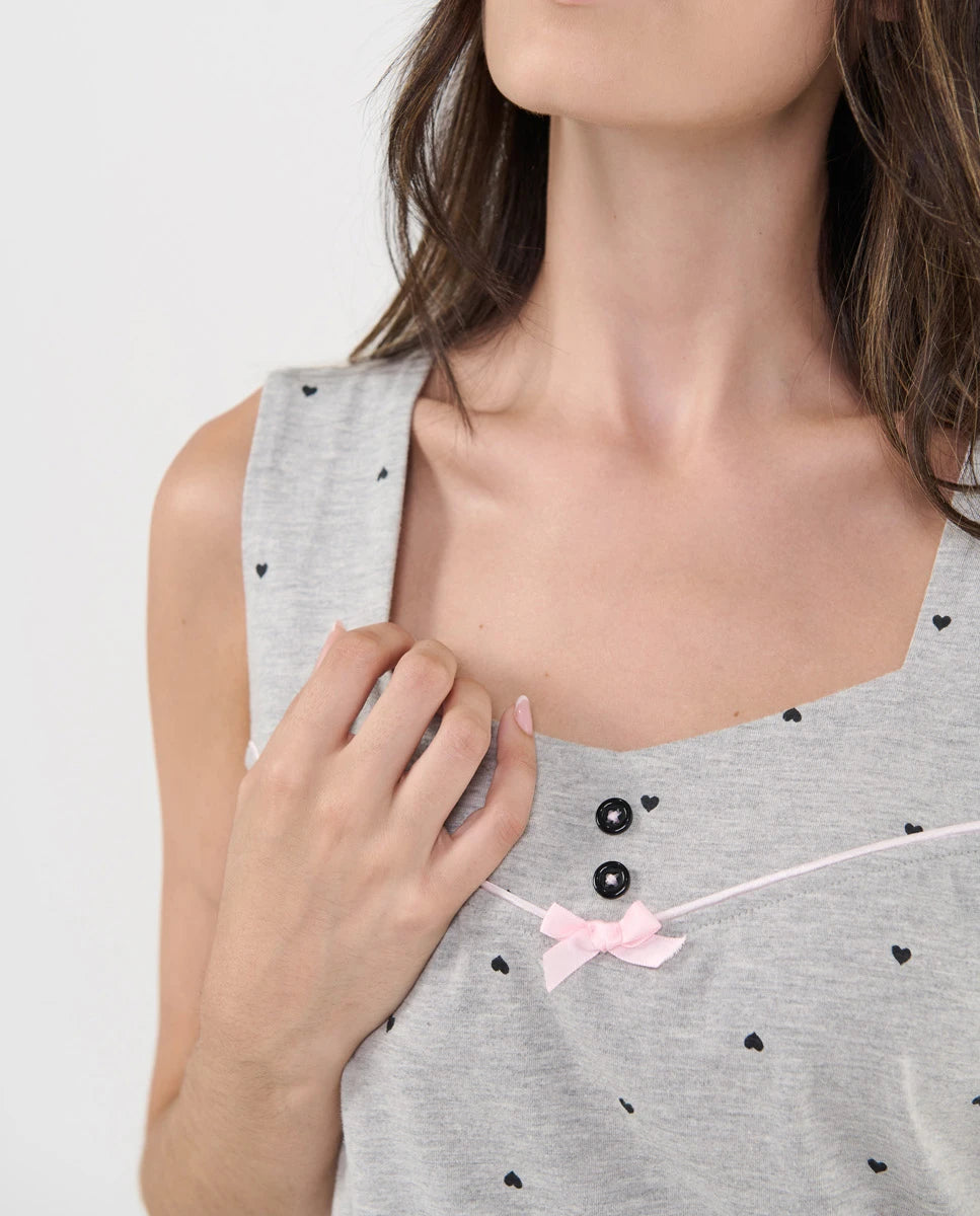 Detalle del escote con botones decorativos, vivo y lazo de raso rosa del top de pijama de tirante ancho